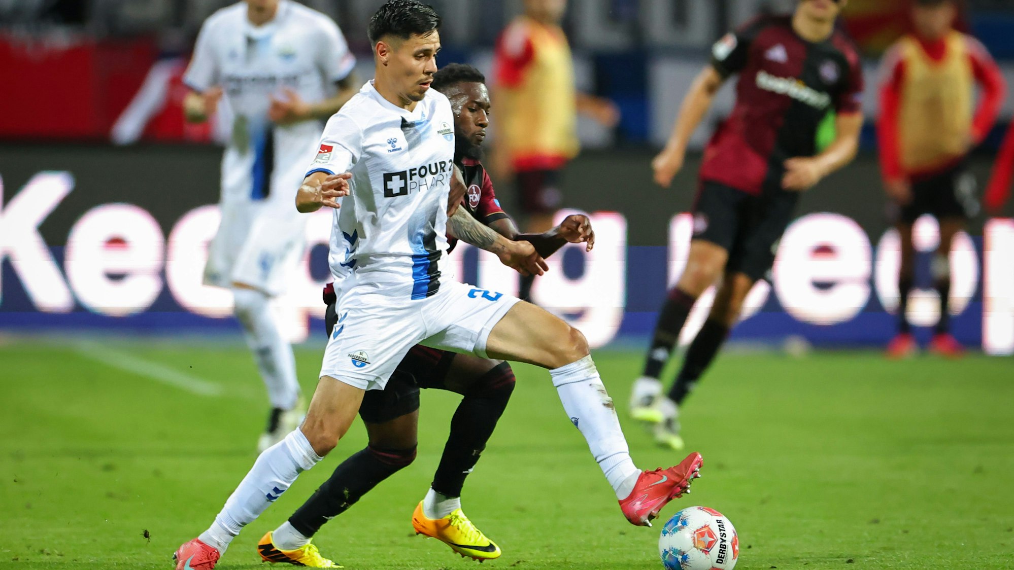 Mickael Biron (M, 1. FC Nürnberg) und Raphael Obermair (SC Paderborn 07, l) kämpfen am Freitag im Zweitligaspiel um den Ball.