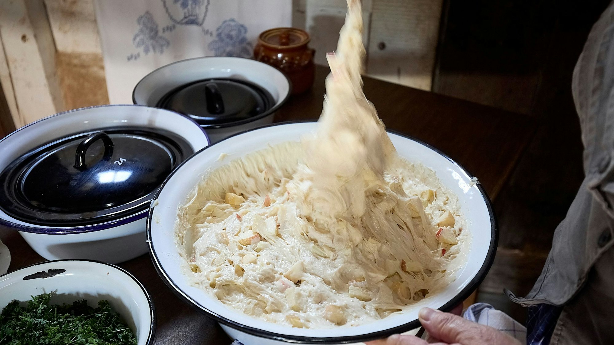 Pfannkuchenteig wird an einem Löffel aus einer Schüssel gezogen.