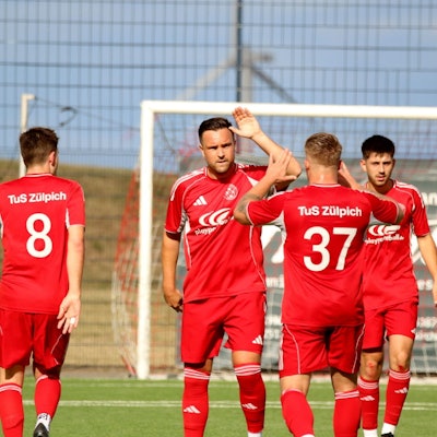 Vier Fußballer jubeln, nachdem ein Tor gefallen ist.