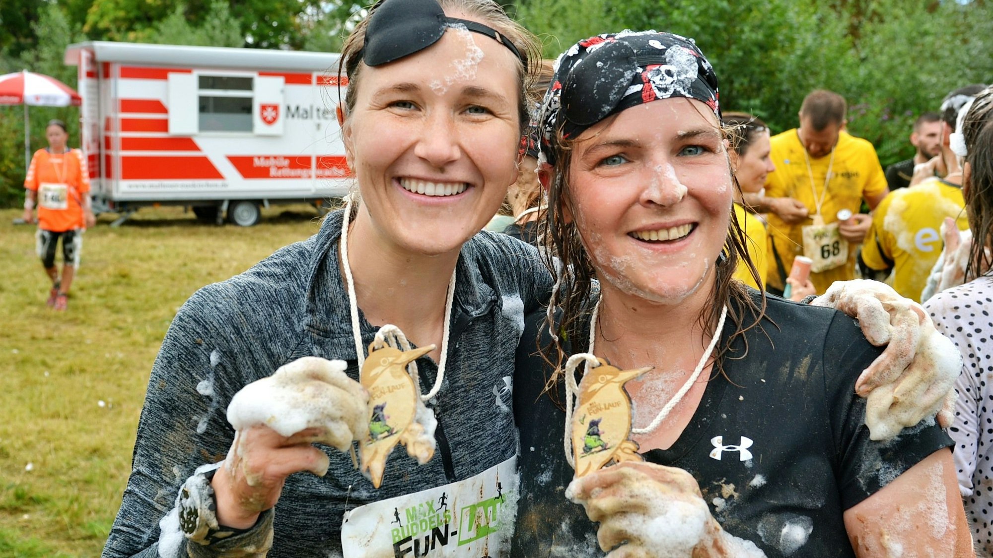 Zwei Teilnehmerinnen präsentieren ihre Medaillen.