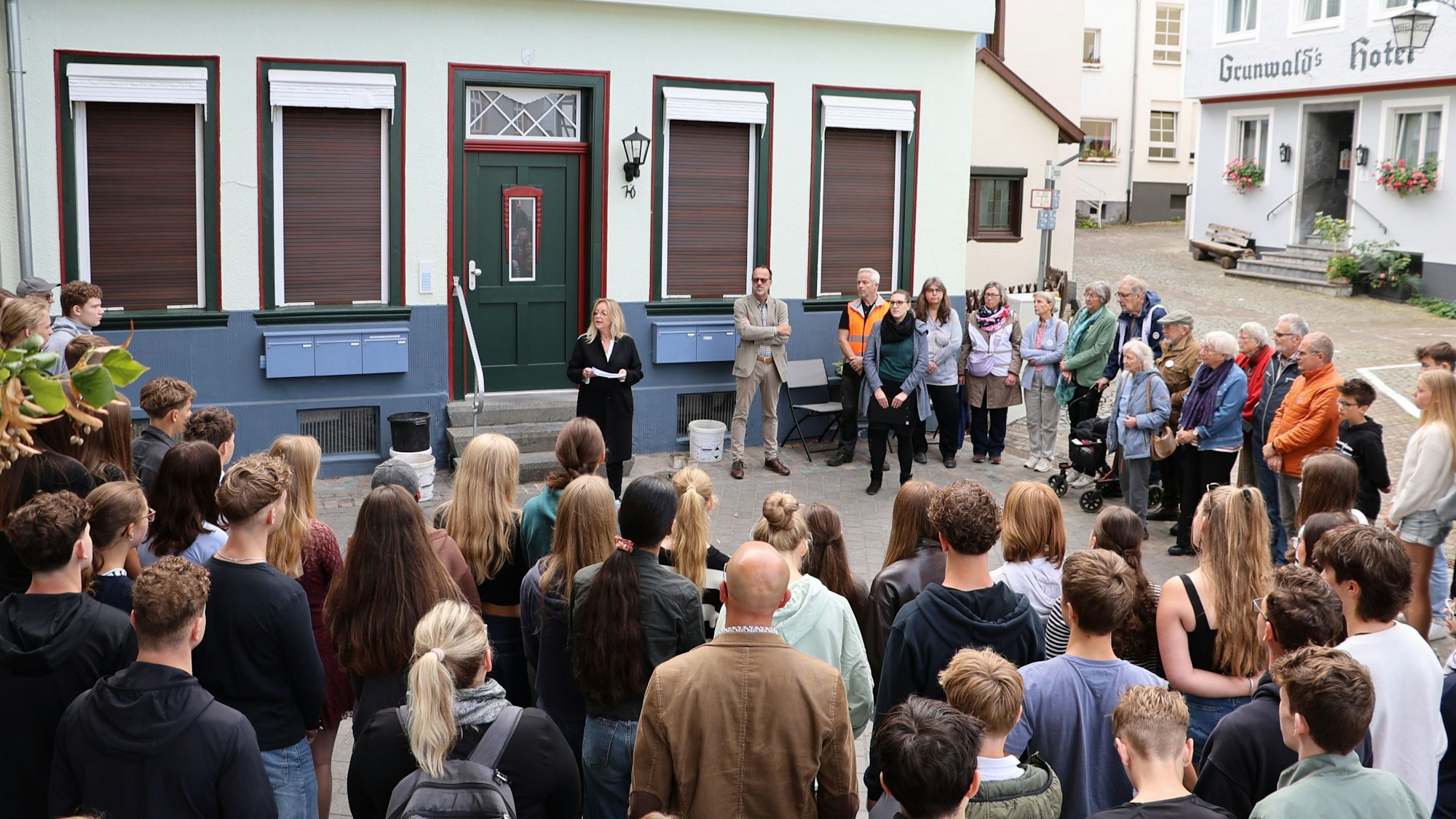Bürgermeisterin Sabine Preiser-Marian spricht vor dem Haus zu einer großen Gruppe von Zuhörern.