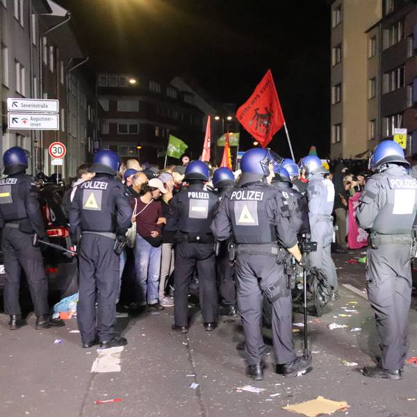 Polizisten stehen Teilnehmern der Demonstration gegenüber.