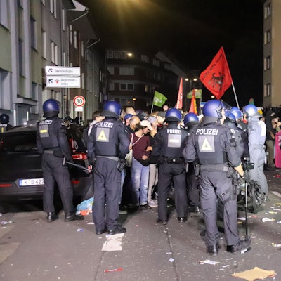 Polizisten stehen Teilnehmern der Demonstration gegenüber.