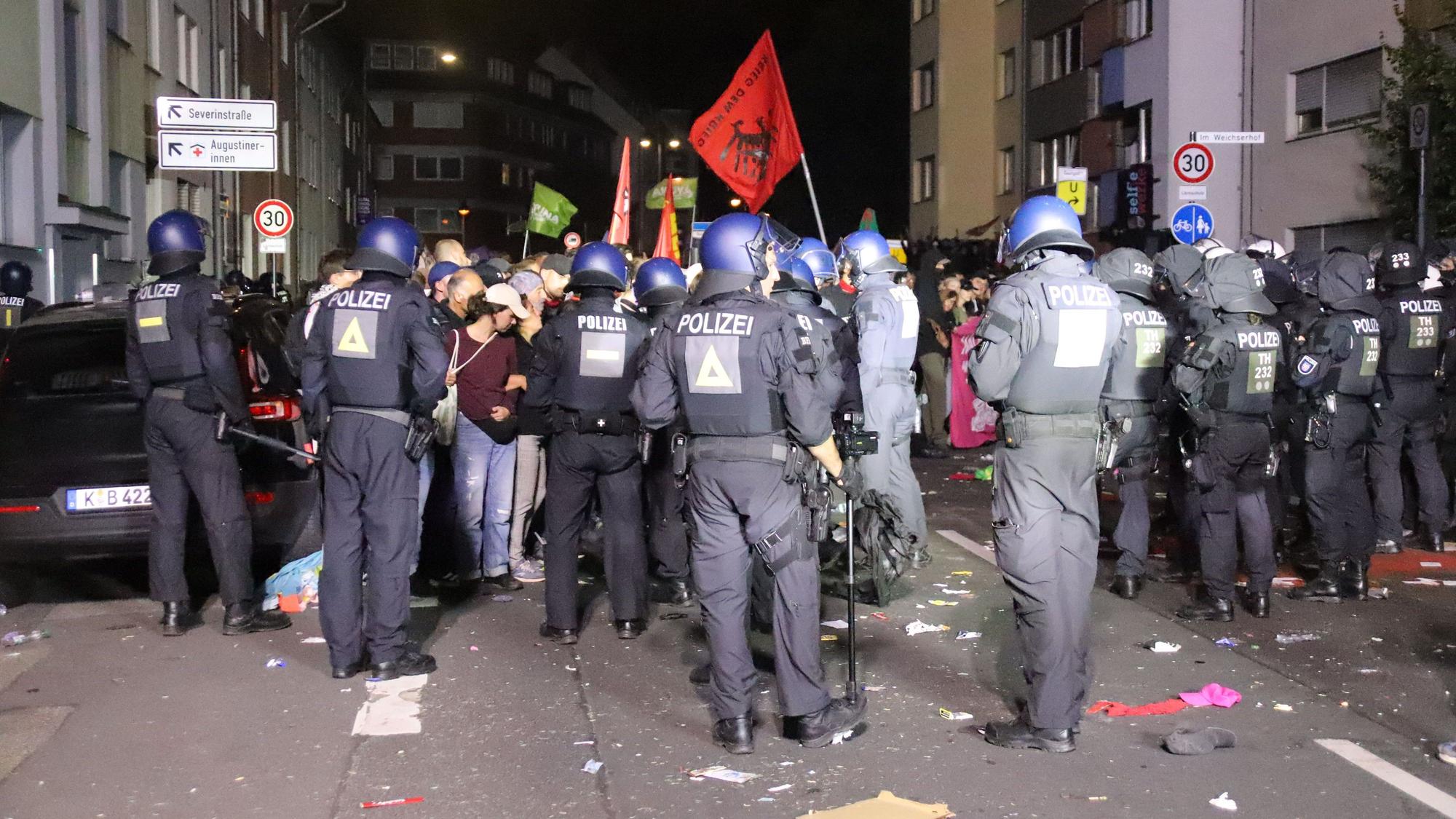 Polizisten stehen Teilnehmern der Demonstration gegenüber.