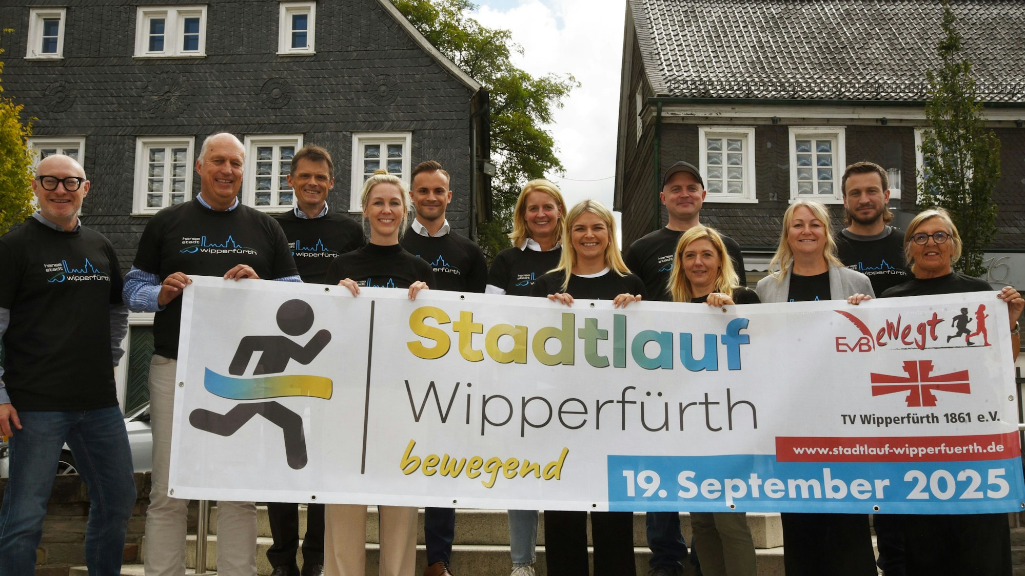 Die Organisatoren des Stadtlaufs präsentieren das Ankündigungsbanner.