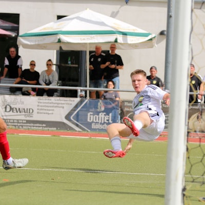 Ein Spieler von Erftstadt-Lechenich liegt quer in der Luft.