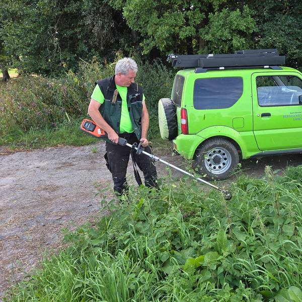 Am Blockhaus-Parkplatz bei Reichshof-Tillkausen wirft Wanderwegemanager Wastl Roth-Seefrid den Freischneider an, um den Zugang zum Bergischen Panoramasteig eindeutig erkennbar zu machen.