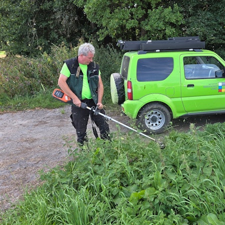 Am Blockhaus-Parkplatz bei Reichshof-Tillkausen wirft Wanderwegemanager Wastl Roth-Seefrid den Freischneider an, um den Zugang zum Bergischen Panoramasteig eindeutig erkennbar zu machen.