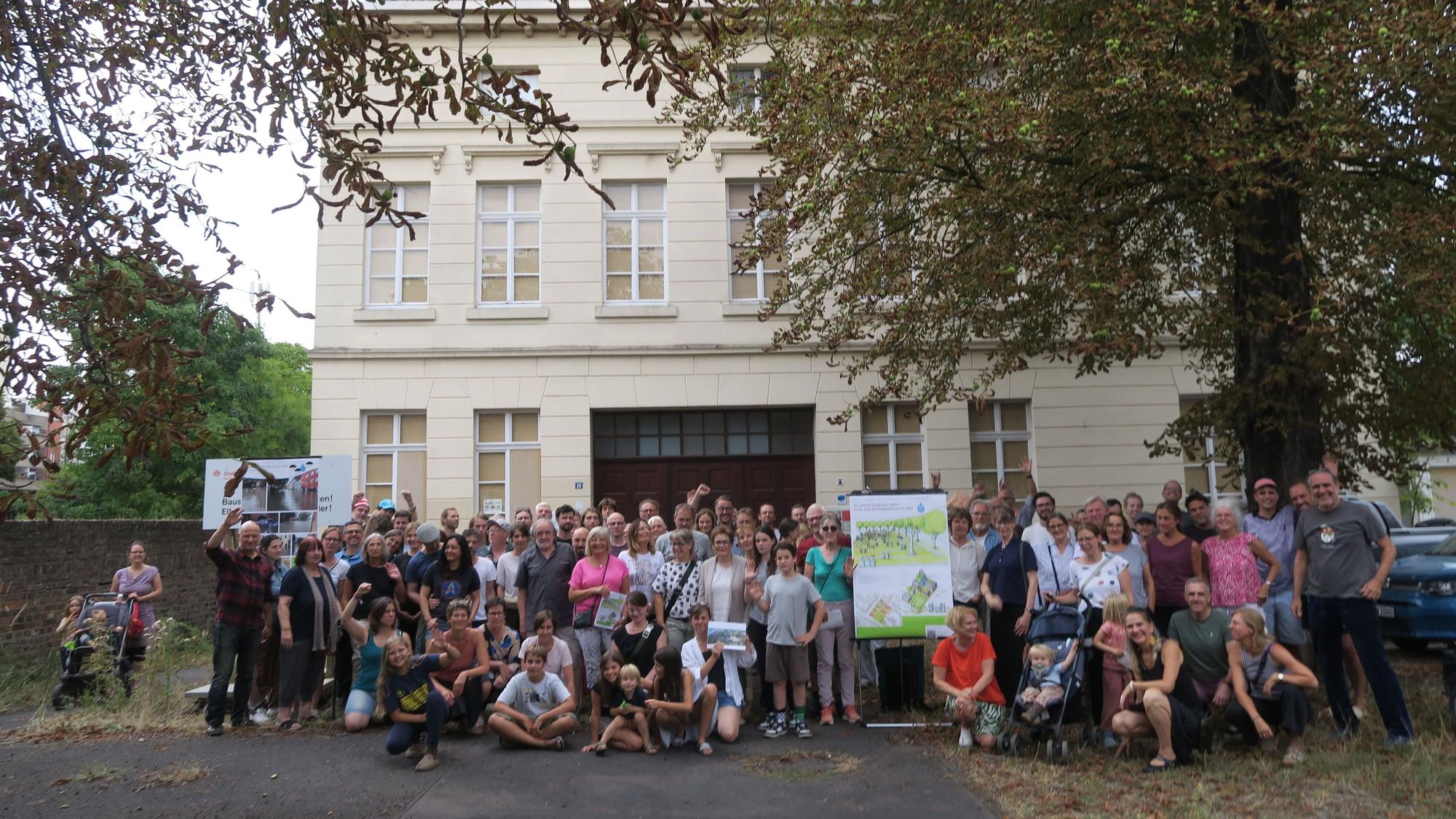 Ein große Gruppe Menschen hat sich vor dem ehemaligen Hauptgebäude des Lindweiler Hofs an der Rochusstraße versammelt.