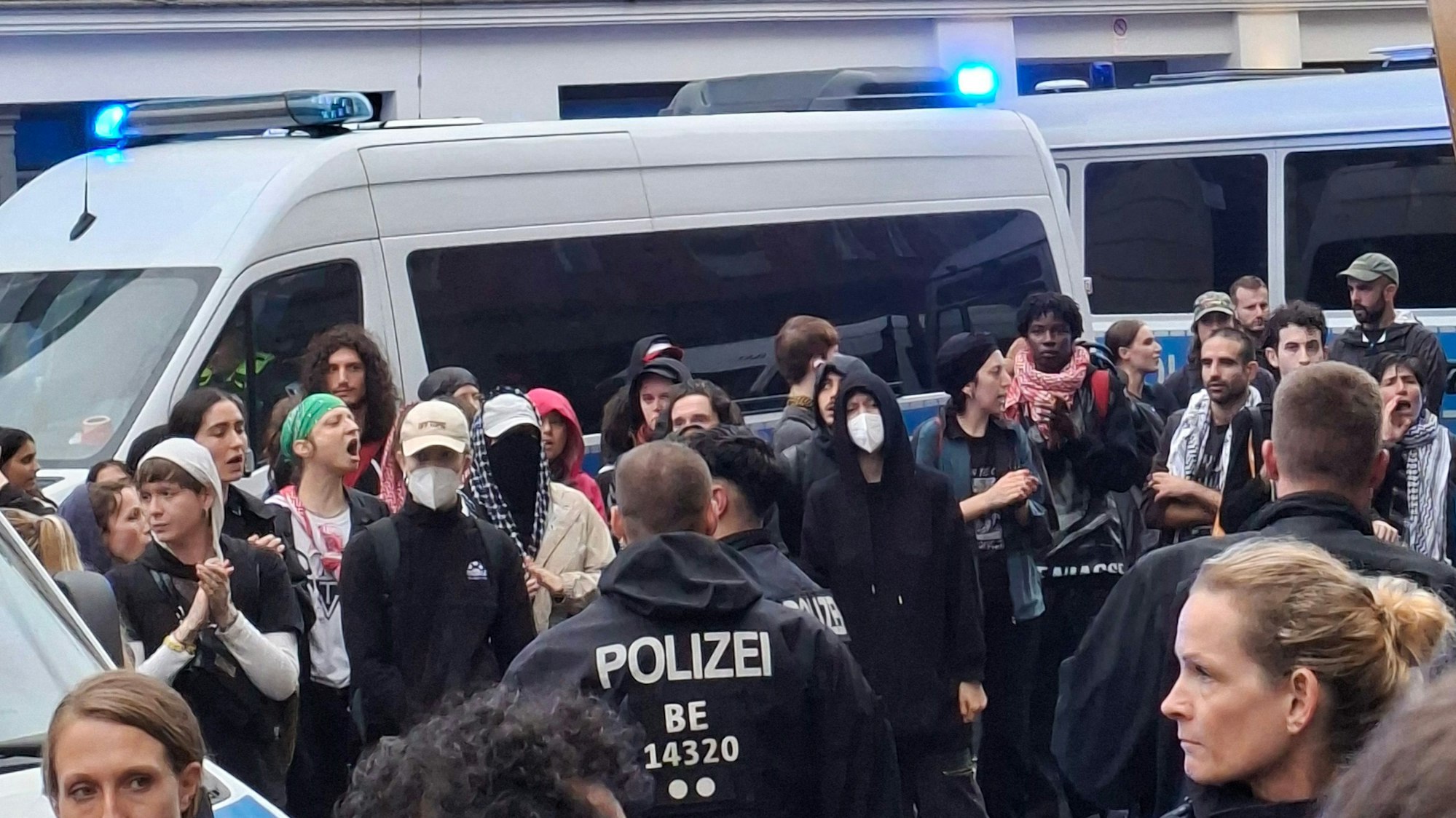 Eine Gruppe von Demonstranten steht vor einem Polizeifahrzeug bei einer propalästinensischen Demonstration nahe dem Hackeschen Markt in Berlin. (Archivbild)