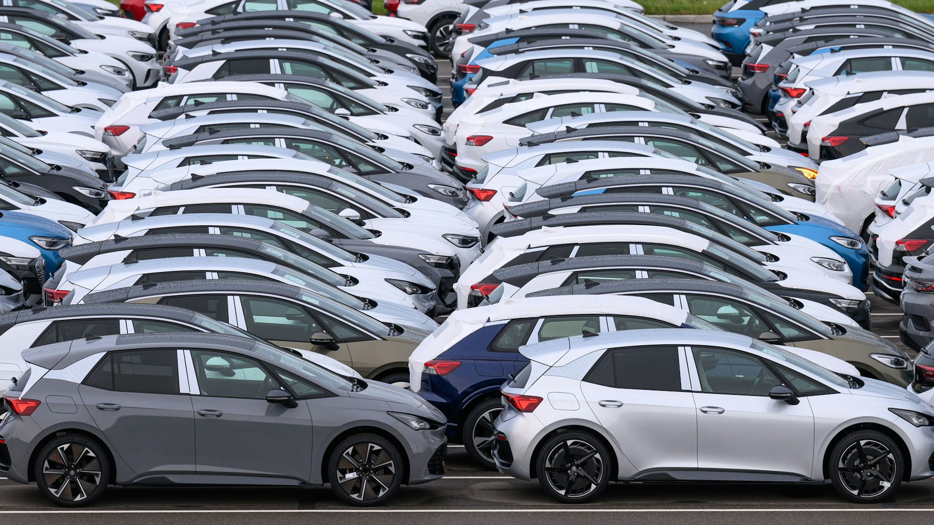 Ein Parkplatz voller Autos, die in mehreren Reihen hintereinander stehen.