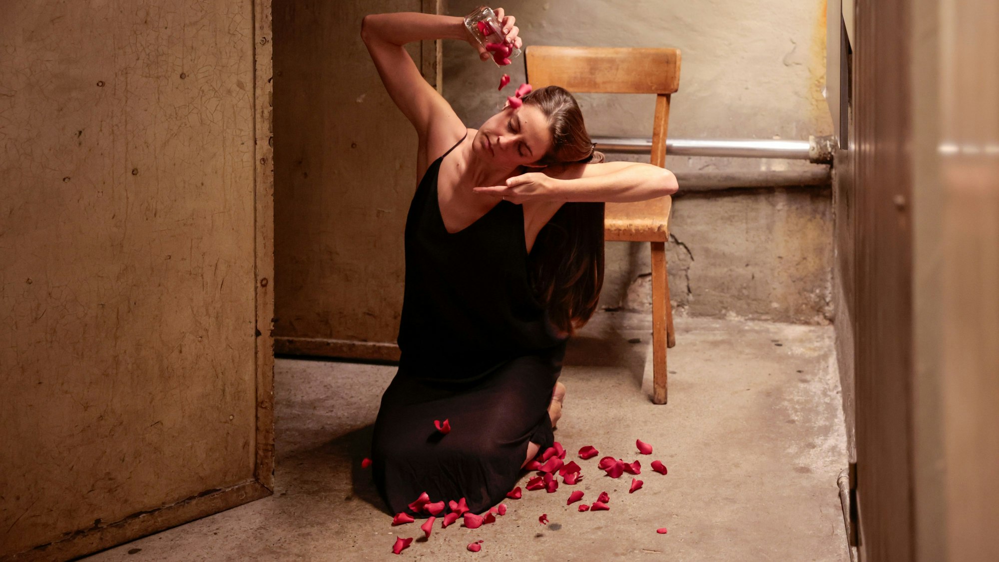 Tänzerin Sara Valenti übergießt ihren Kopf mit Rosenblättern.