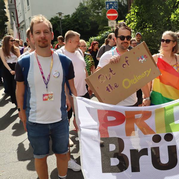 Zu sehen sind Demonstrationsteilnehmer, die ein buntes Banner mit der Aufschrift „Pride Brühl“ tragen.