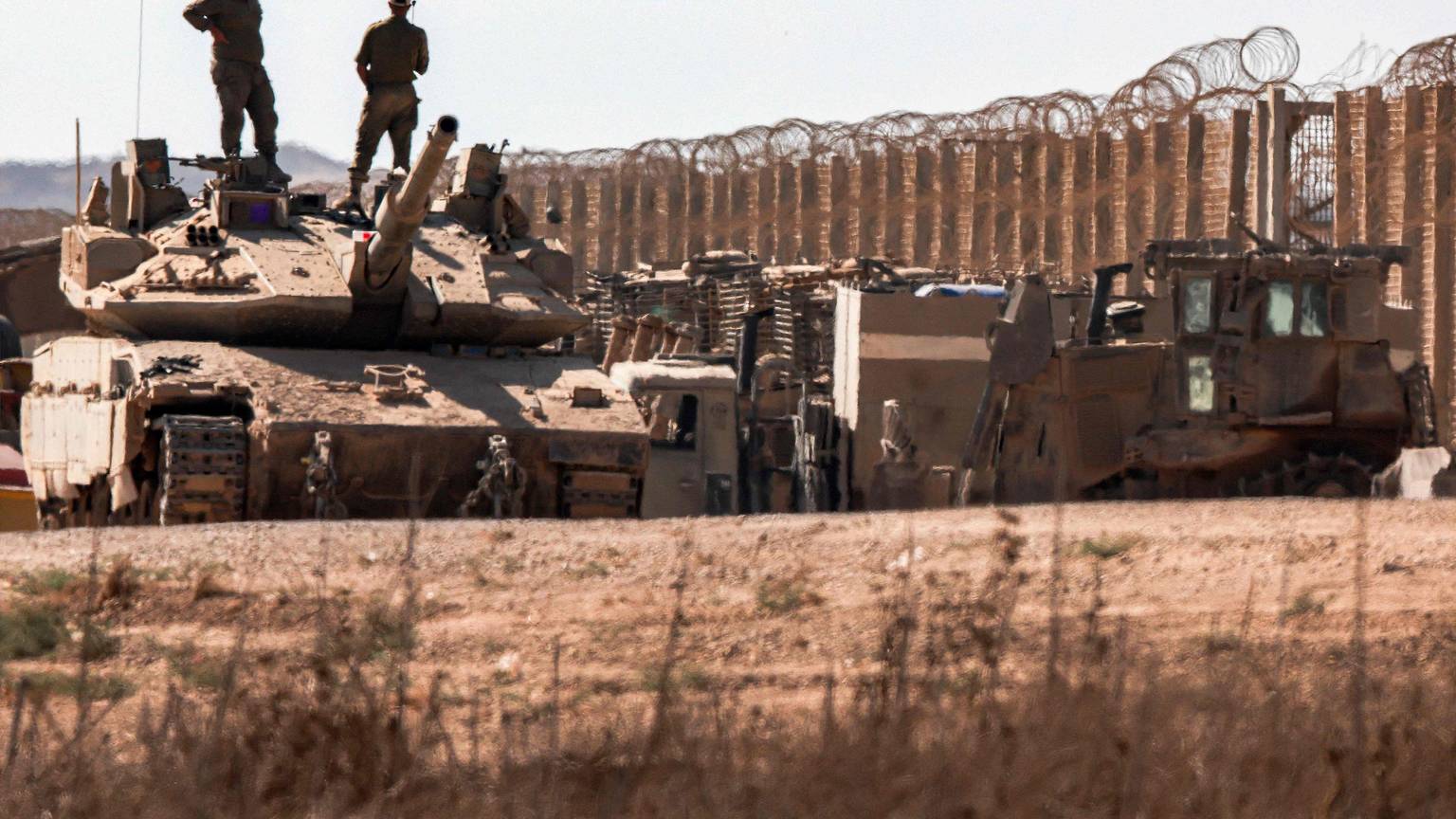 Israelische Soldaten stehen auf einem Panzer am Grenzzaun zum Gazastreifen.