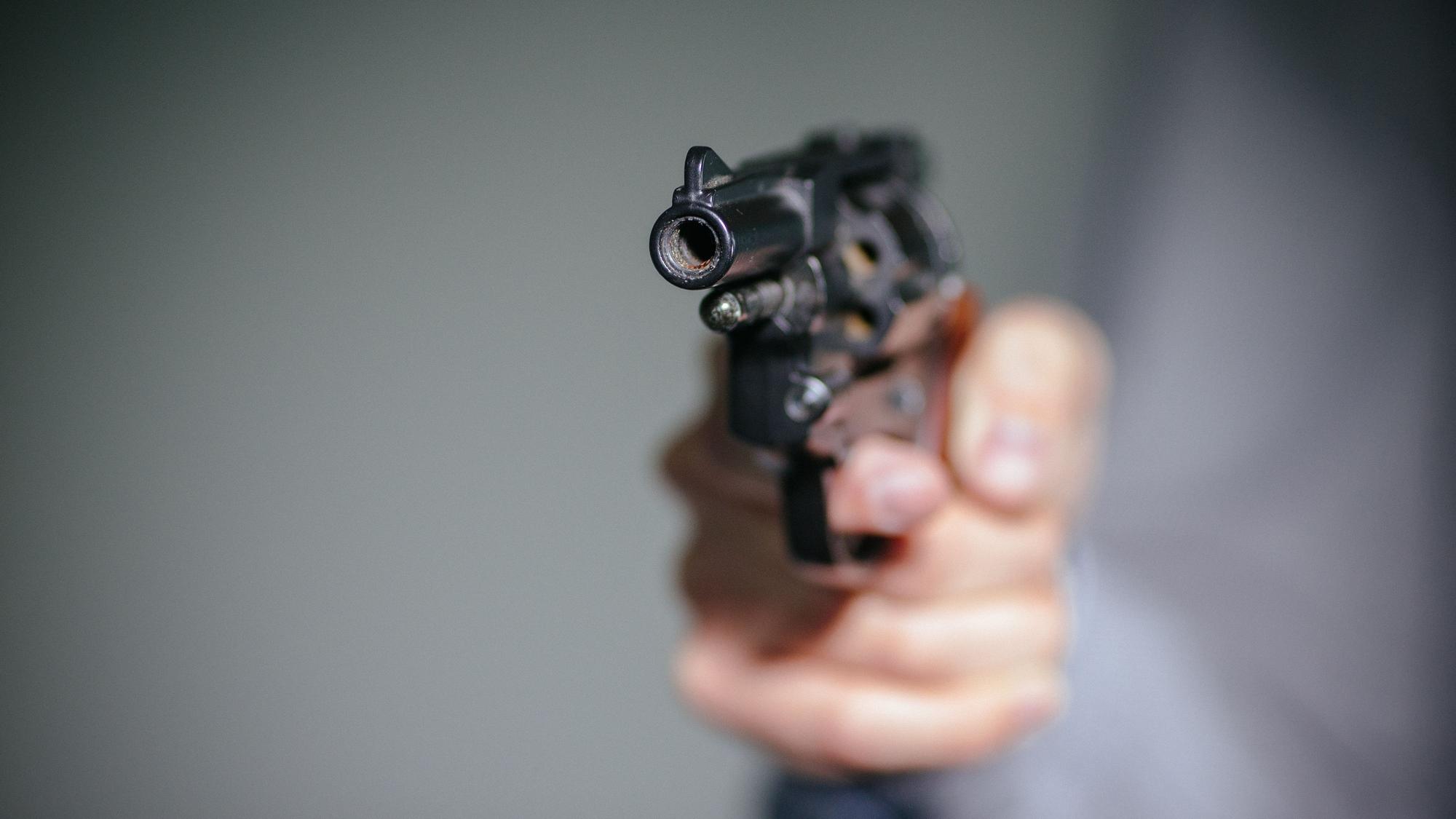 Ein Mensch hält einen Schreckschuss-Revolver in der Hand.