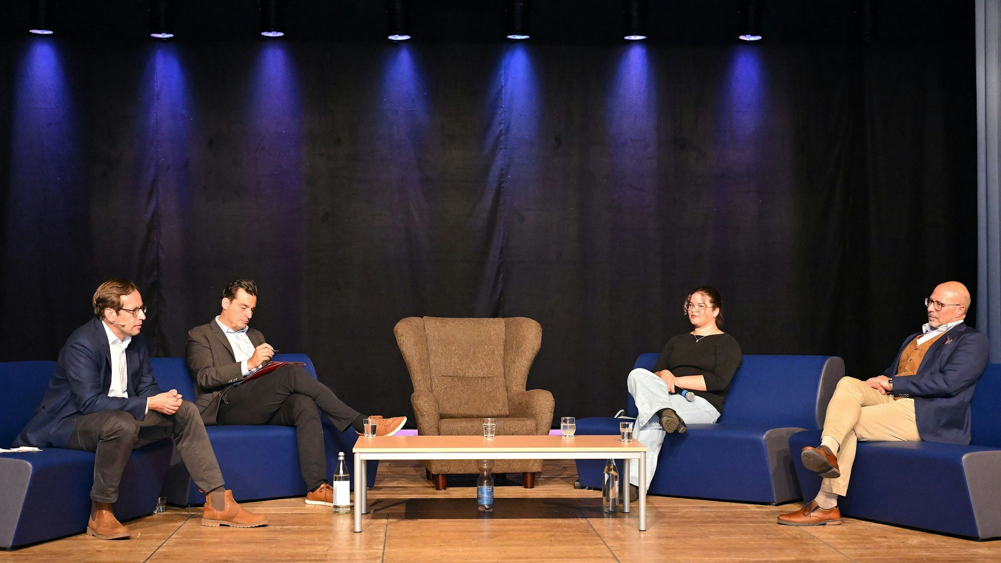 Vier Leute sitzen auf einem Sofa.