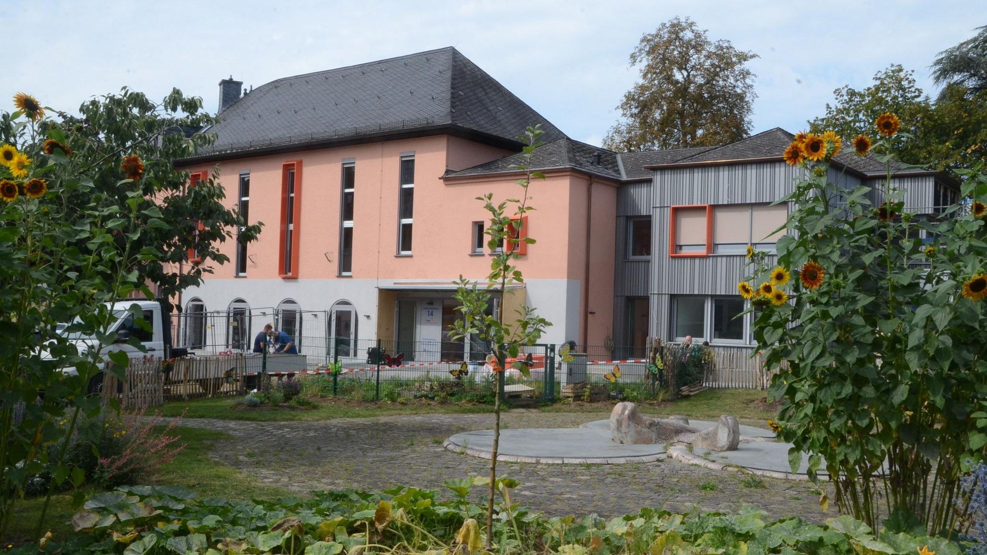 Blick ein großes Haus mit einem kleineren Anbau.