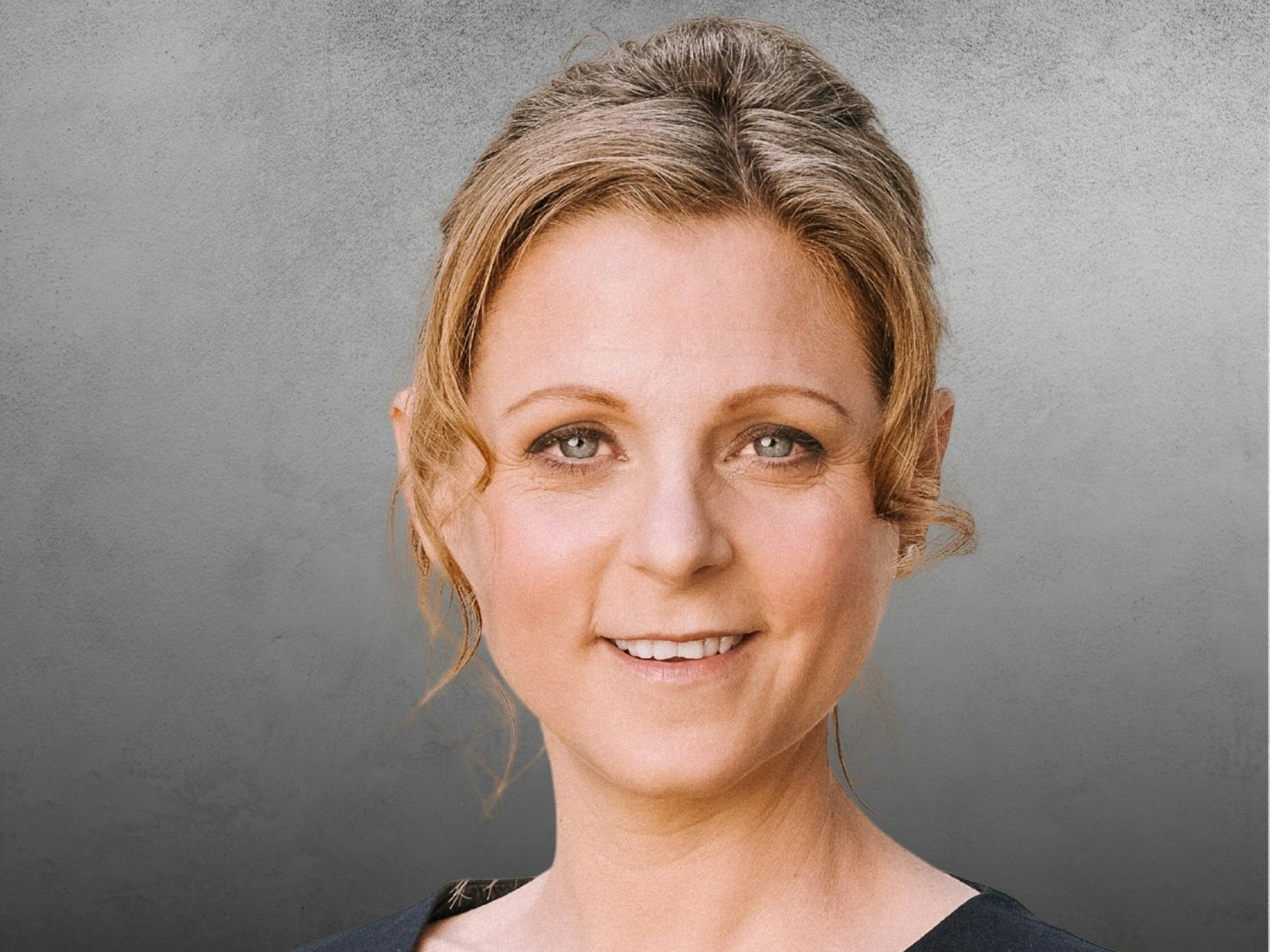 Myriam Kemp lächelt vor einem neutralen Hintergrund.