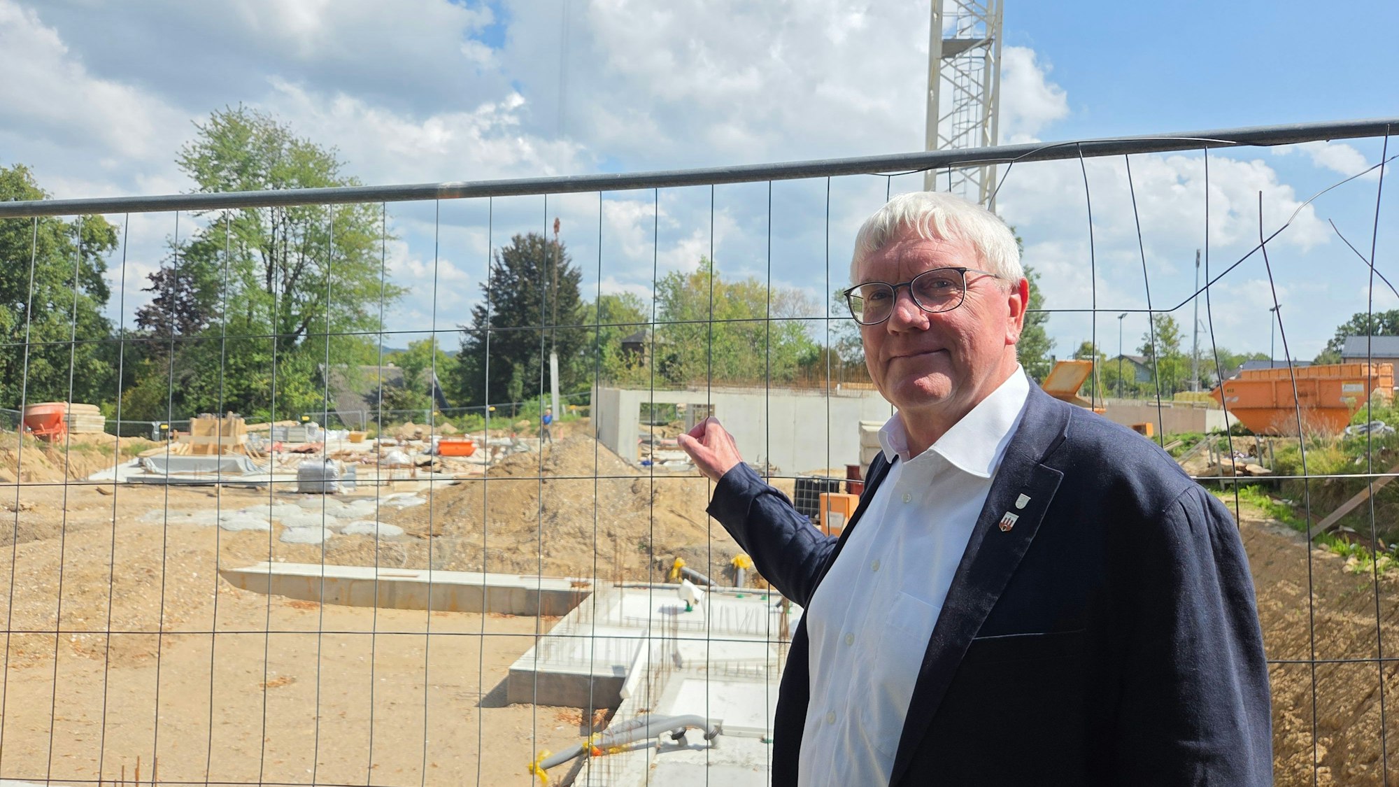 Amtsinhaber Sebastian Schuster will Landrat bleiben und stellt sich zur Kommunalwahl 2025 erneut zur Wahl. Hier steht er vor der Baustelle zum neuen Kultur- und Heimathaus in Hennef-Stadt Blankenberg.