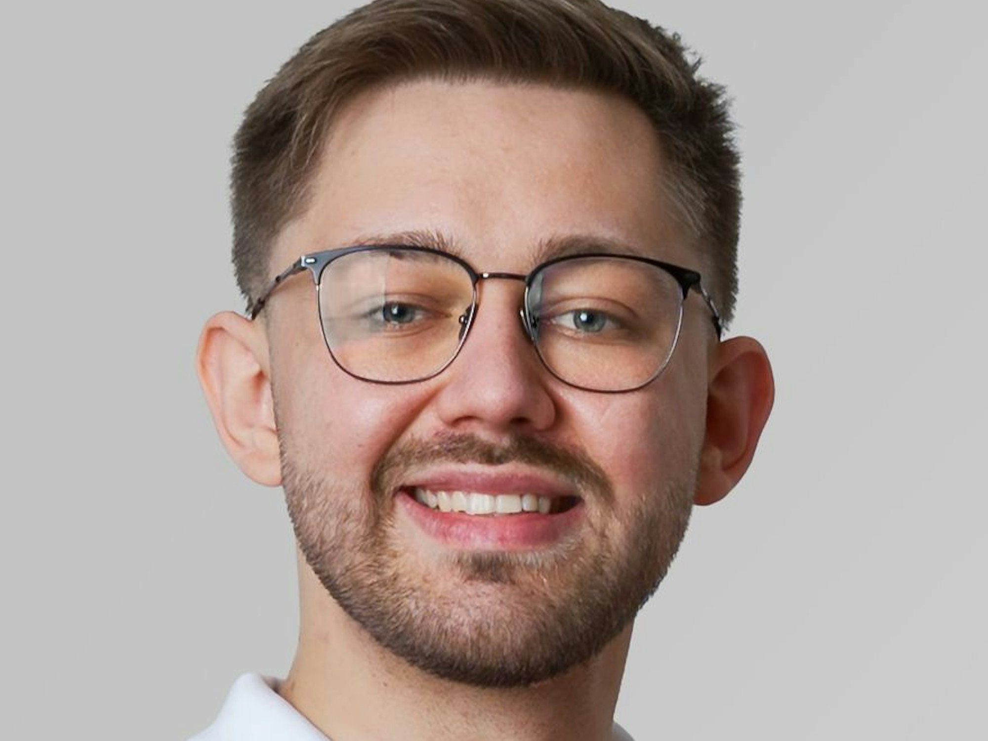 Porträtbild von Daniel Knopf mit weißem T-Shirtkragen.