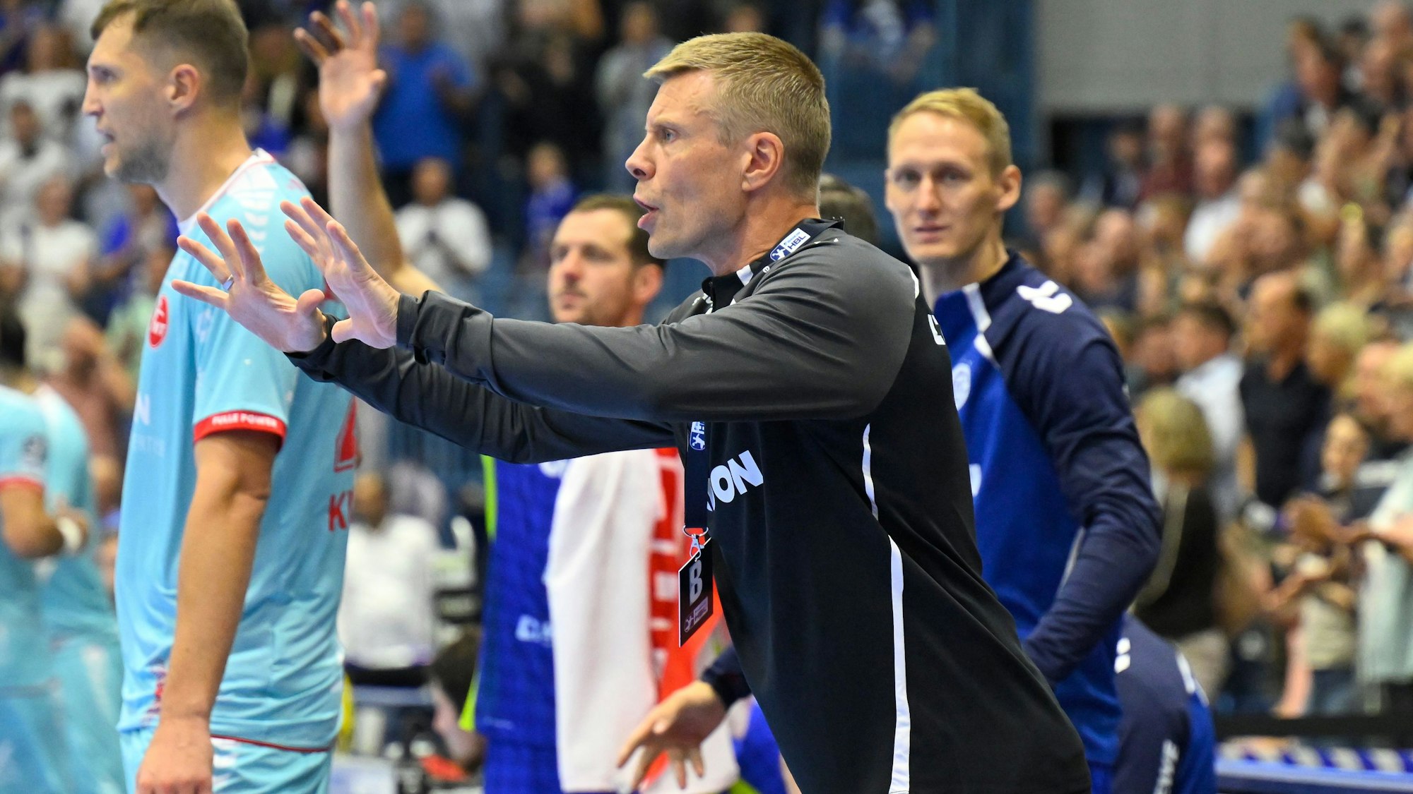 Ein Handball-Trainer gibt seiner Mannschaft Anweisungen.