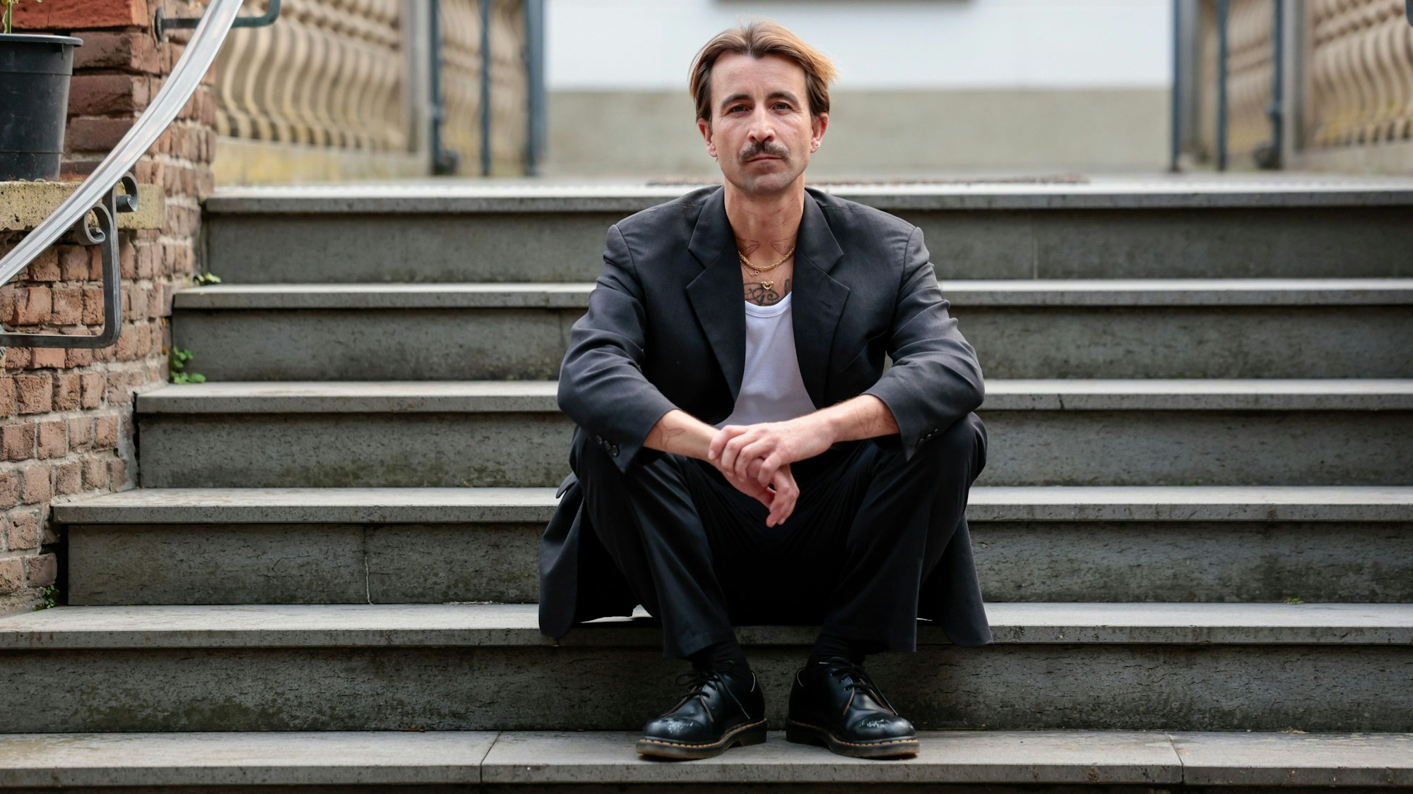 Kurator David Roth auf den Treppen des Schlösschens in Sülz