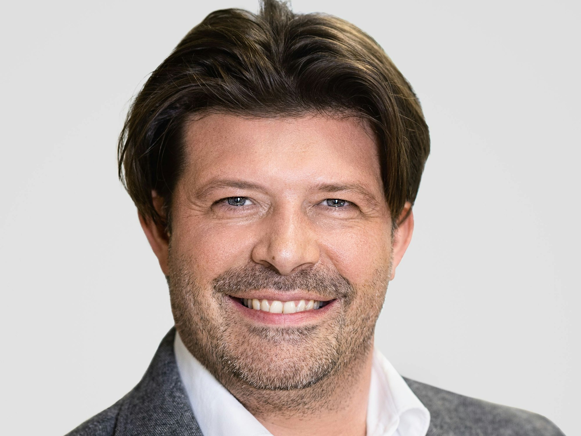 Porträtfoto von Arne Spitz vor neutralem Hintergrund.