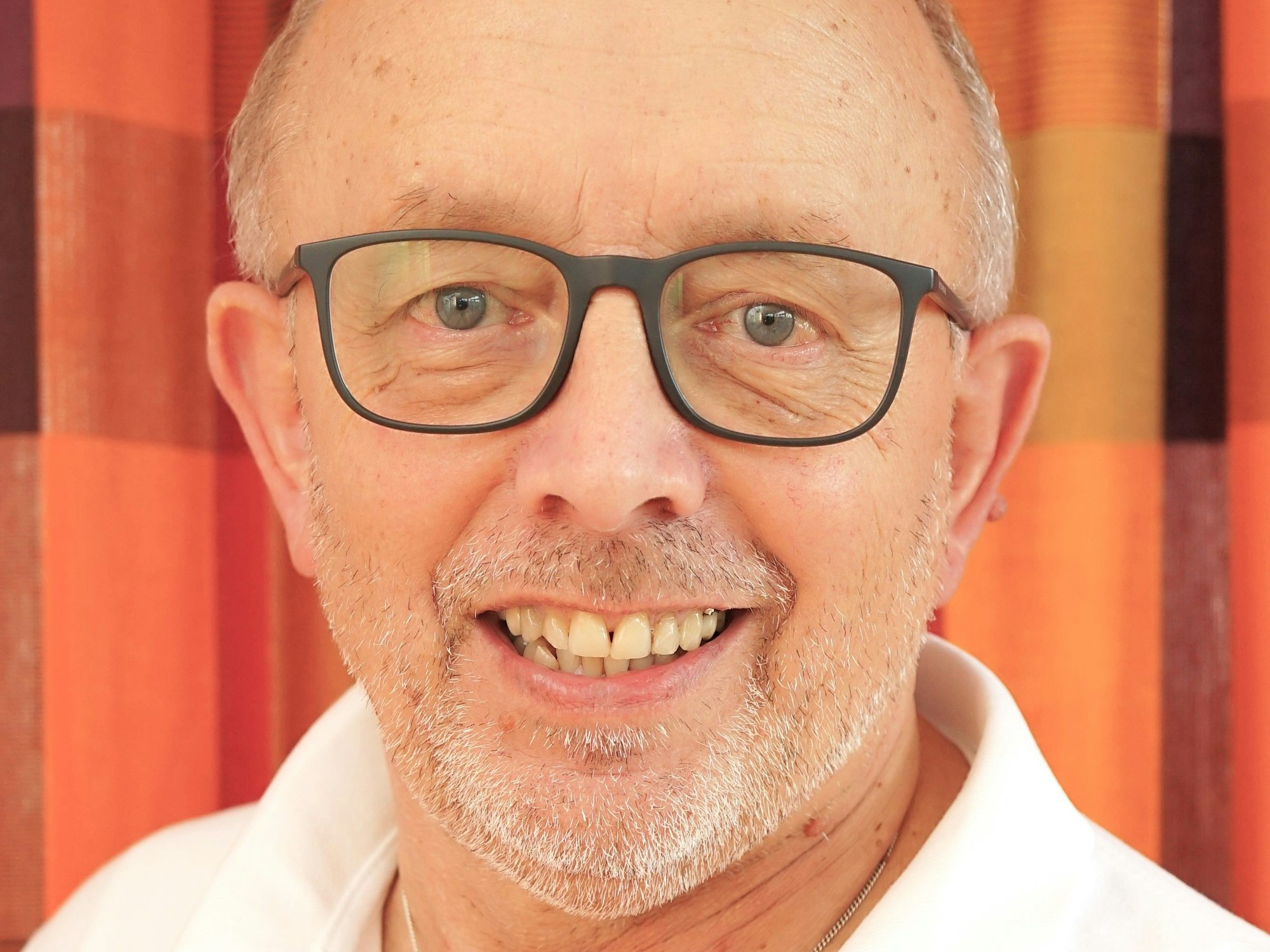 Porträtbild von Karl Vermöhlen mit einem weißen T-Shirt mit Kragen.