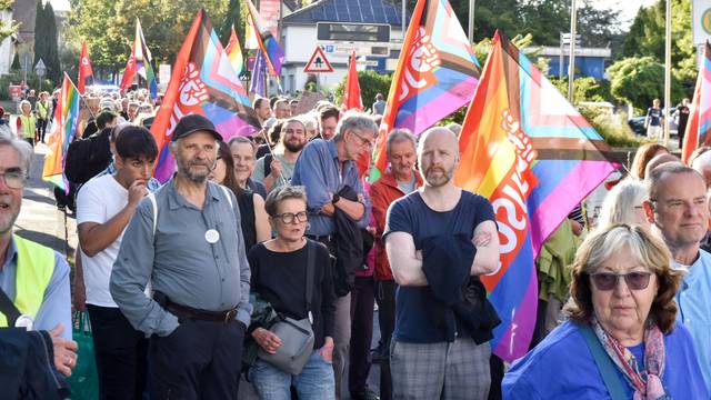 Auf dem Bild sind Demonstranten mit bunten Fahnen zu sehen.