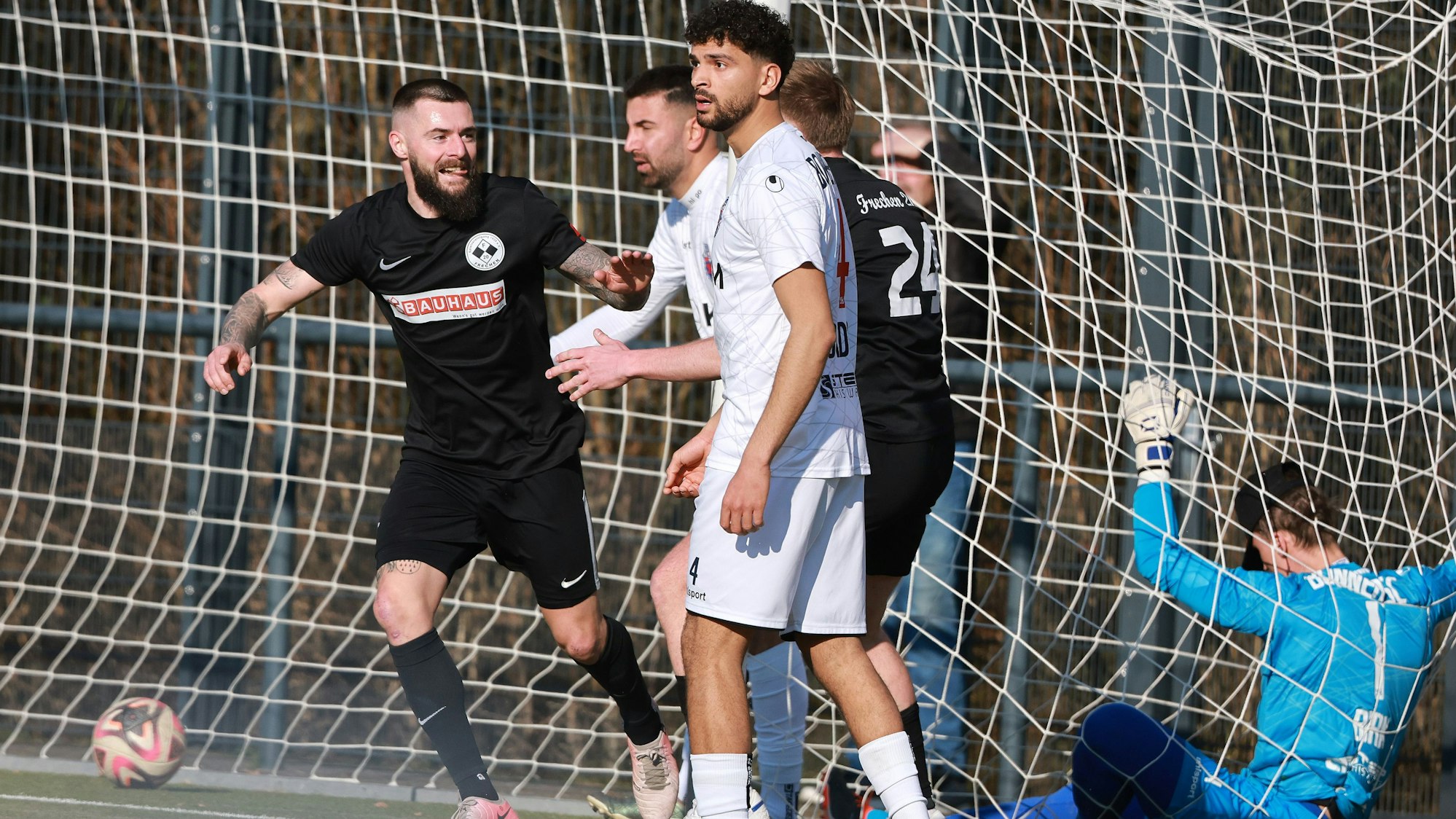 Das Foto zeigt einen Fußballer, der sein Tor bejubelt, Ball und gegnerischer Torwart liegen im Netz.