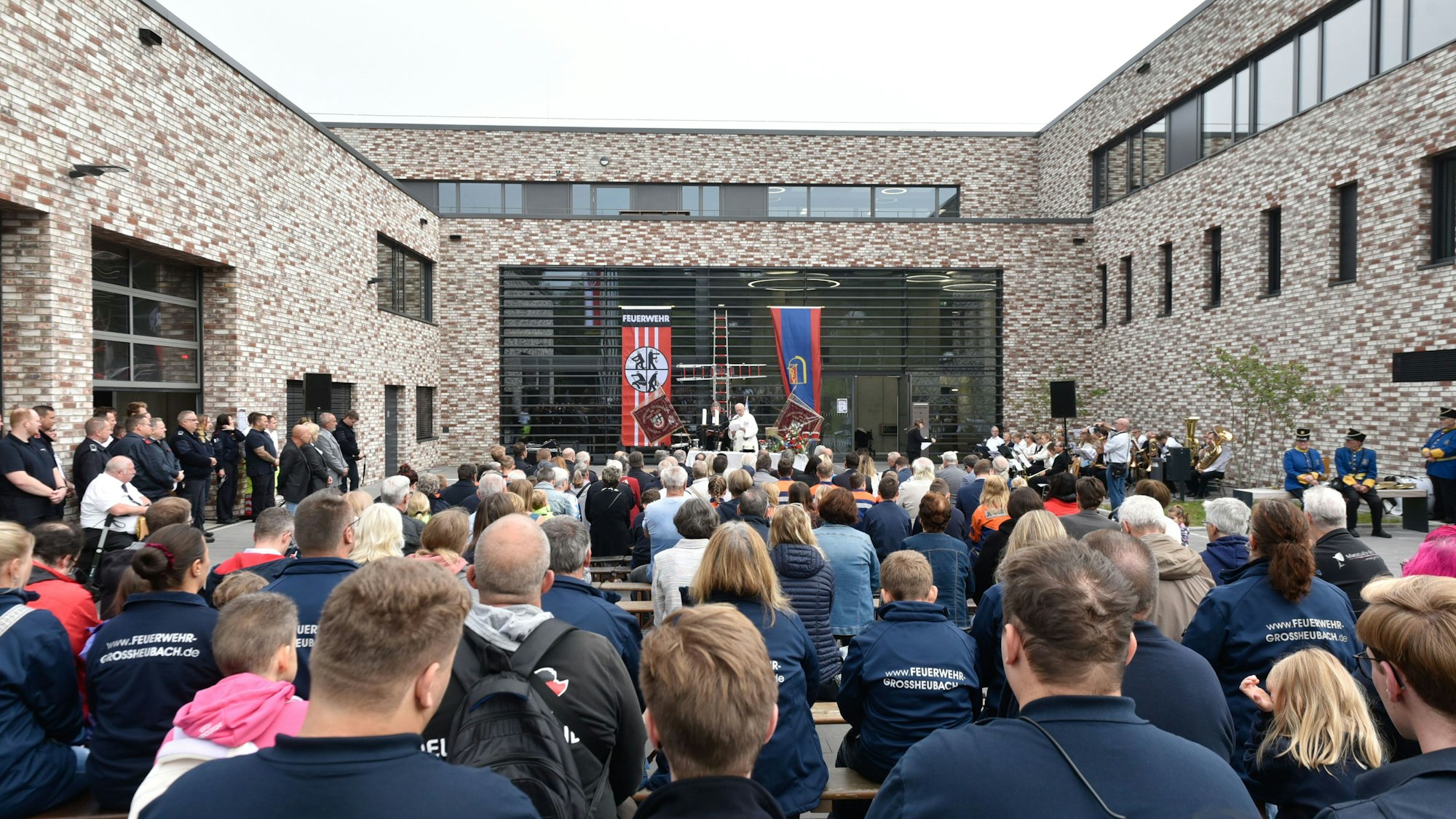 Das Bild zeigt die vielen Besucher der Einweihung von hinten, die einer Rede lauschen.