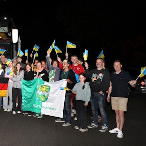 Mit Ukrainefähnchen winken die Bergisch Gladbacher Gastfamilien in der Nacht zu Montag (8.9.) ihren jungen Gästen aus Butscha.
