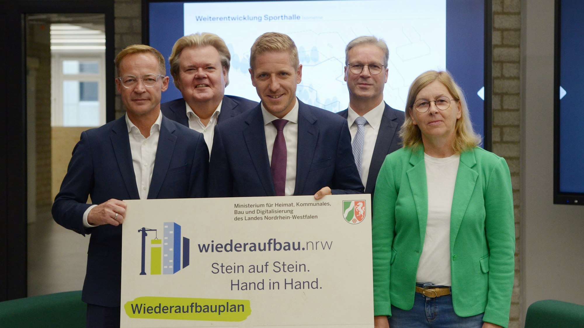 Vier Männer und eine Frau stehen in zwei Reihen beisammen.