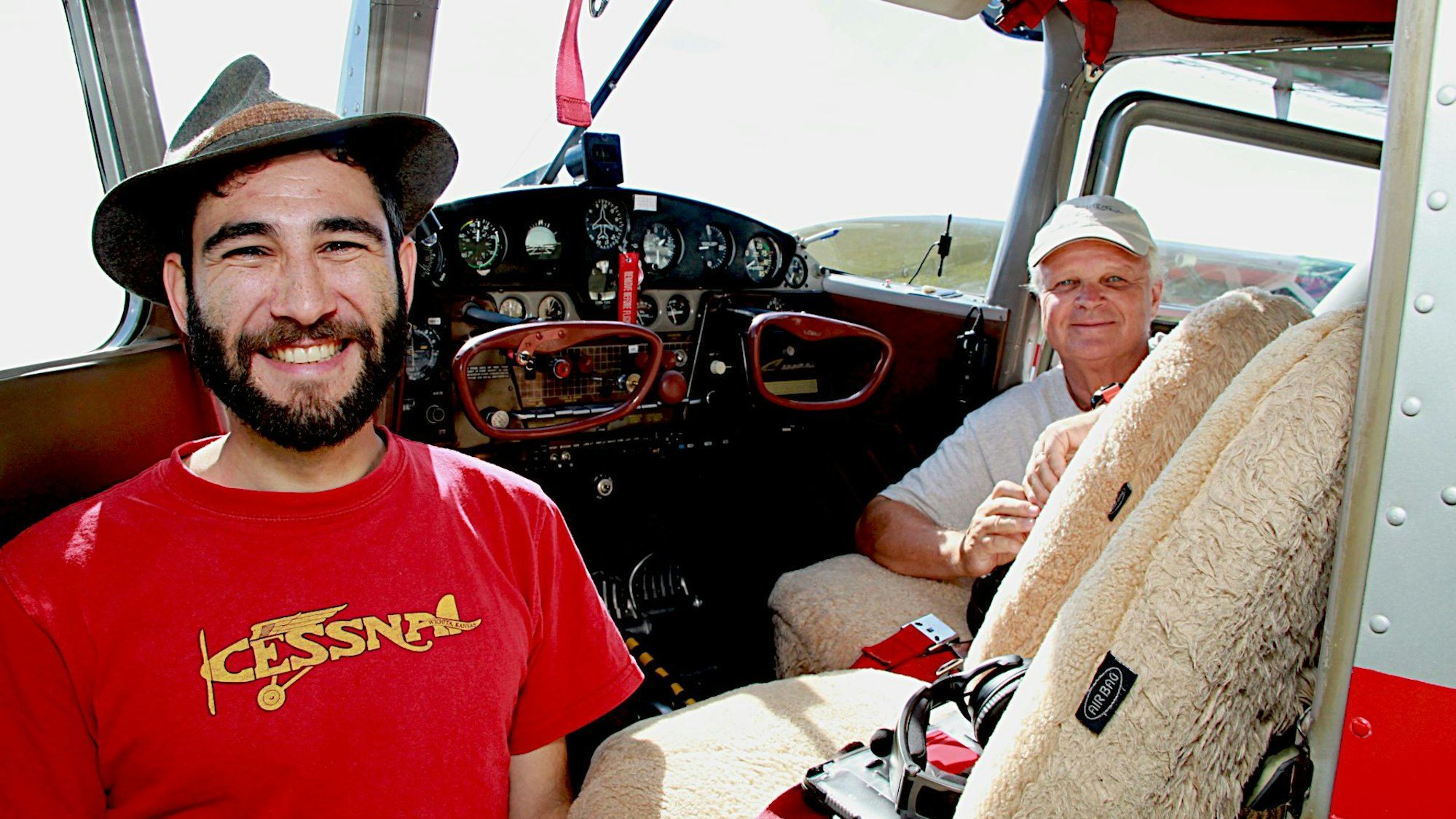 Zwei Männer stehen vor dem Cockpit ihres Cessna-Flugzeugs.