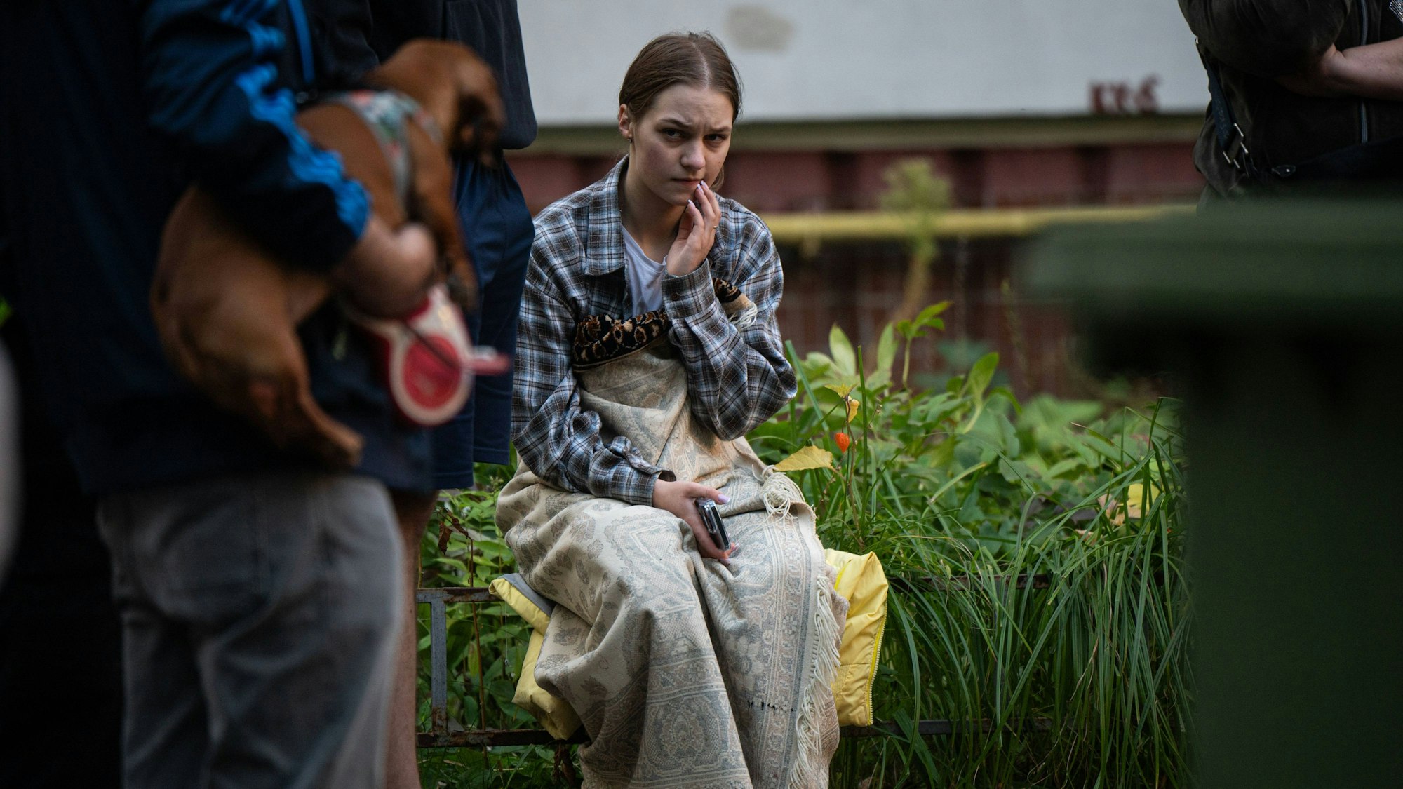 Eine junge Ukrainerin sitzt vor einem Apartmentgebäude, nachdem eine russische Drohne das Haus getroffen hatte. Zwei Menschen starben bei dem Angriff. (Archivbild)