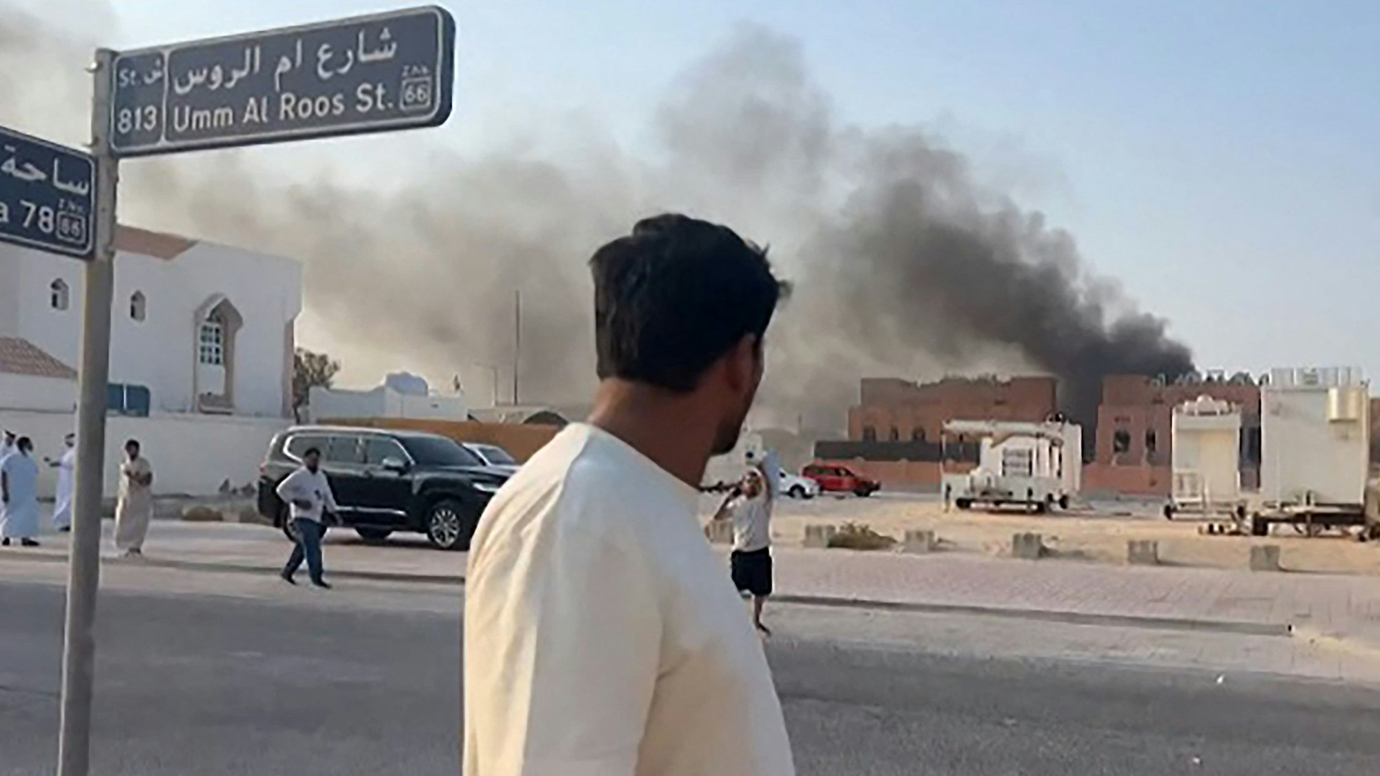 Ein Standbild aus einem AFPTV-Video zeigt einen Mann, der nach Explosionen in der Hauptstadt Katars, Doha, aufsteigenden Rauch beobachtet.