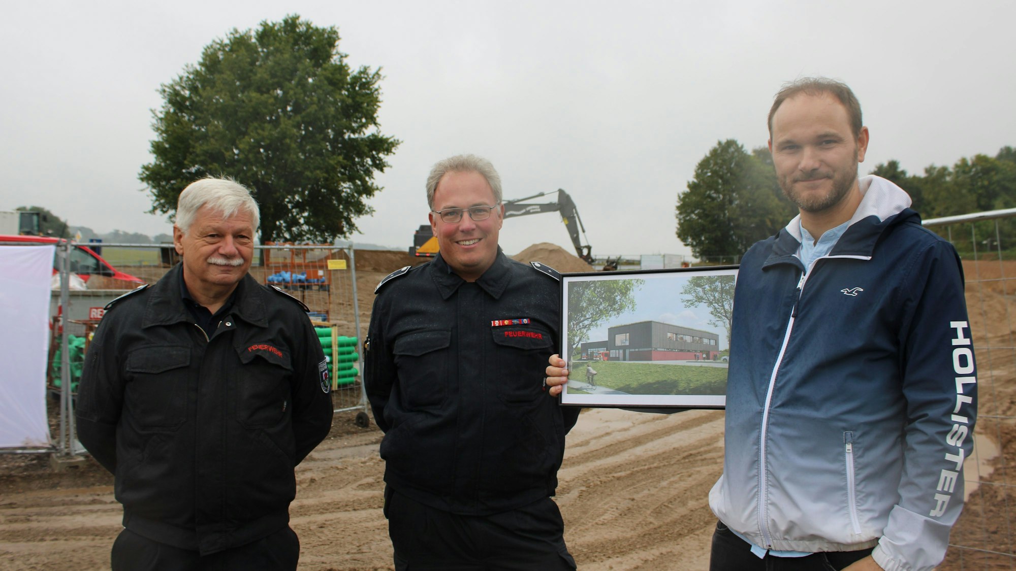 Peter Völkerath, Timo Meiländer und Thomas Pokall zeigen eine Visualisierung des neuen Gerätehauses.