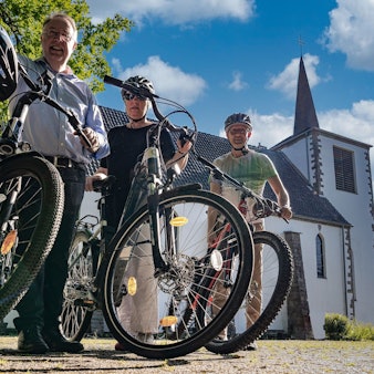 In und auch um die Culturkirche in Engelskirchen-Osberghausen ist immer viel los. Diakon Patrick Oetterer (links) hat zusammen mit Bernhard Wunder und Udo Wallraf auch eine Radtour rund um die Kirche entwickelt.