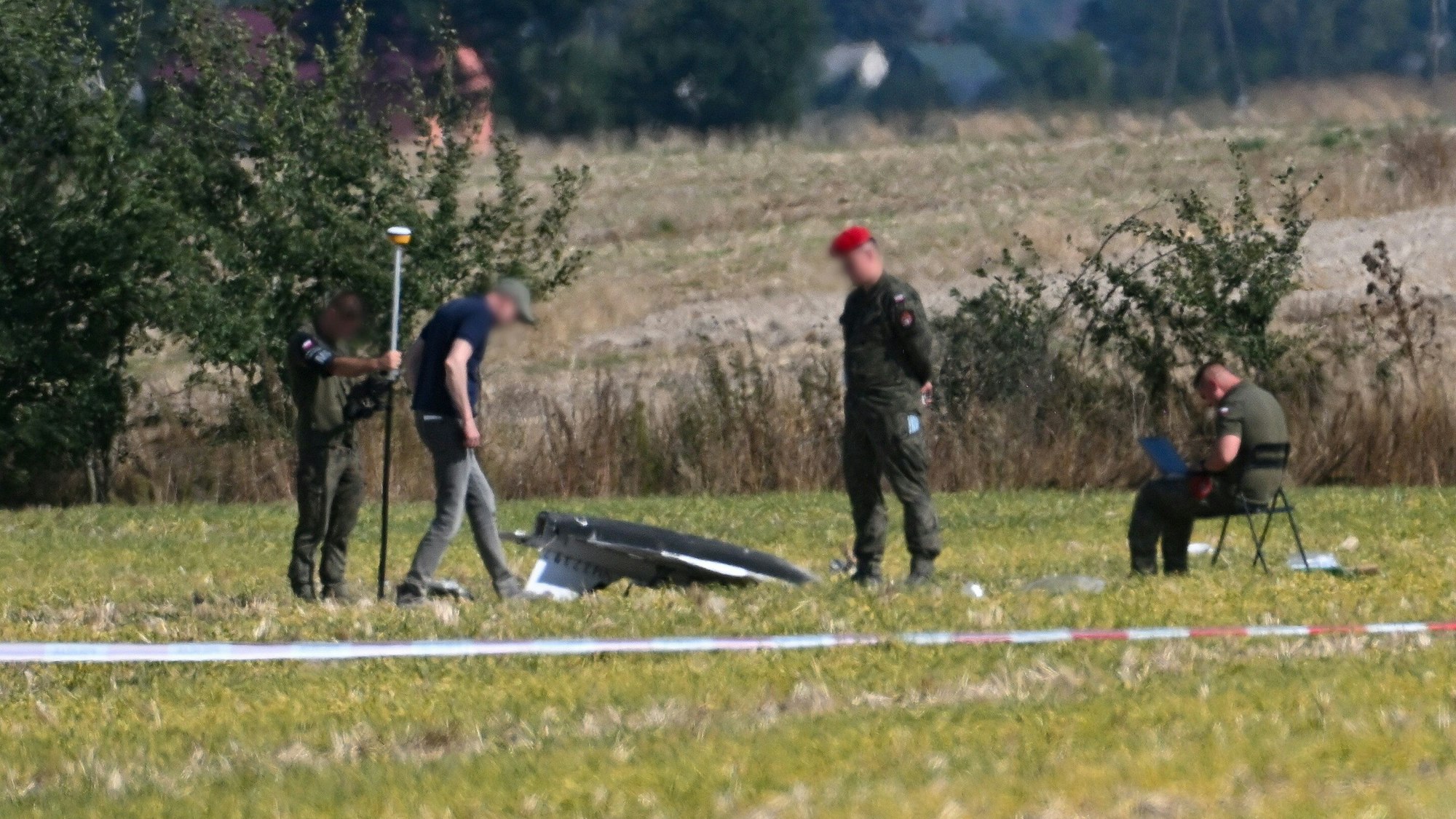 10.09.2025, Polen, Wohyn: Polizei und Militärpolizei sichern Teile einer beschädigten Drohne, die von polnischen Behörden abgeschossen wurde, auf einem Gelände in Wohyn.