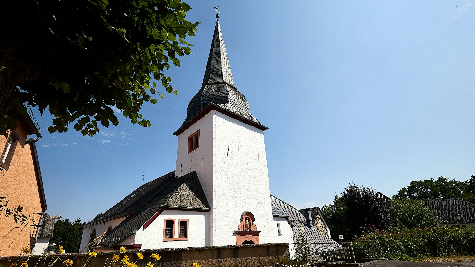 Die Pfarrkirche St. Martin in Schmidtheim ist weiß gestrichen, das Dach mit Schiefer gedeckt.