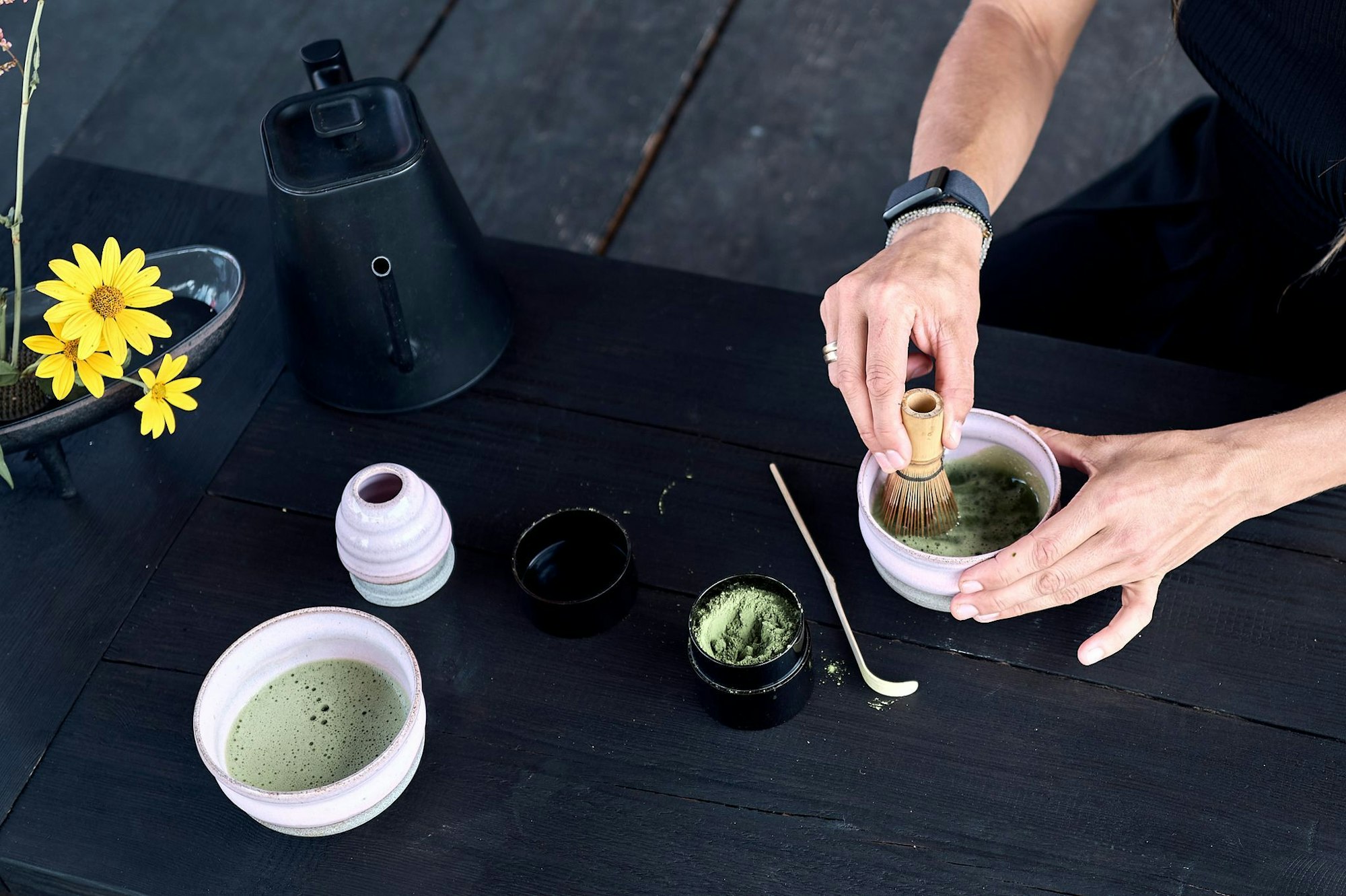 Das Matcha-Pulver wird mit Wasser und einem Besen schaumig geschlagen.
