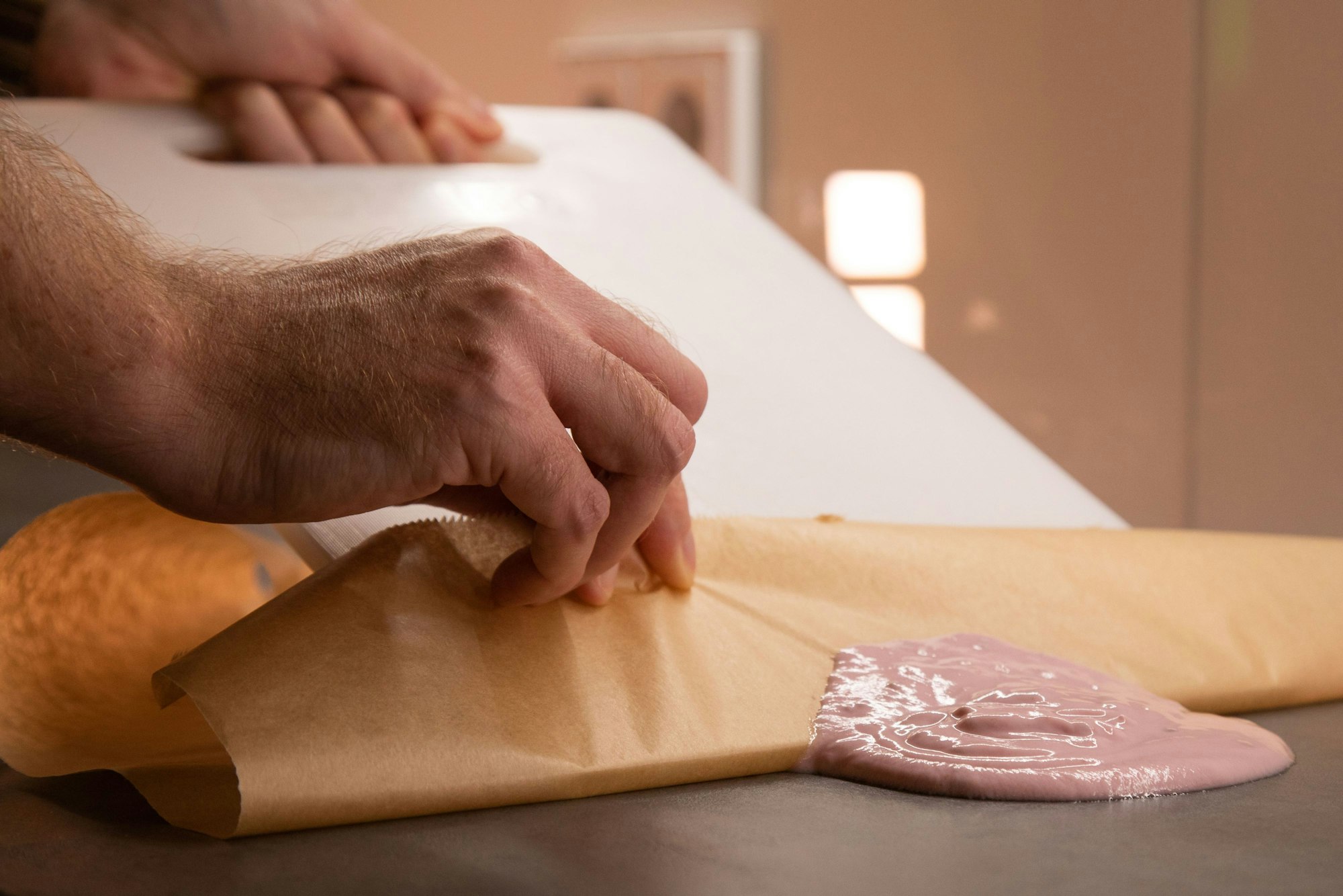Schritt 2: Mit Hilfe des Schneidebretts den Joghurt auf das Backpapier schieben.