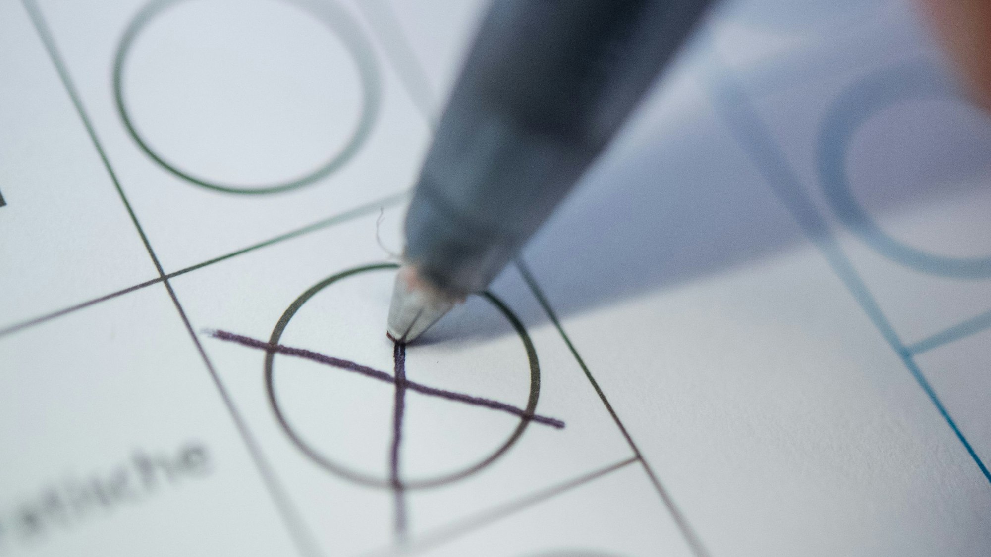 Eine Frau macht ein Kreuz auf einem Wahlzettel.