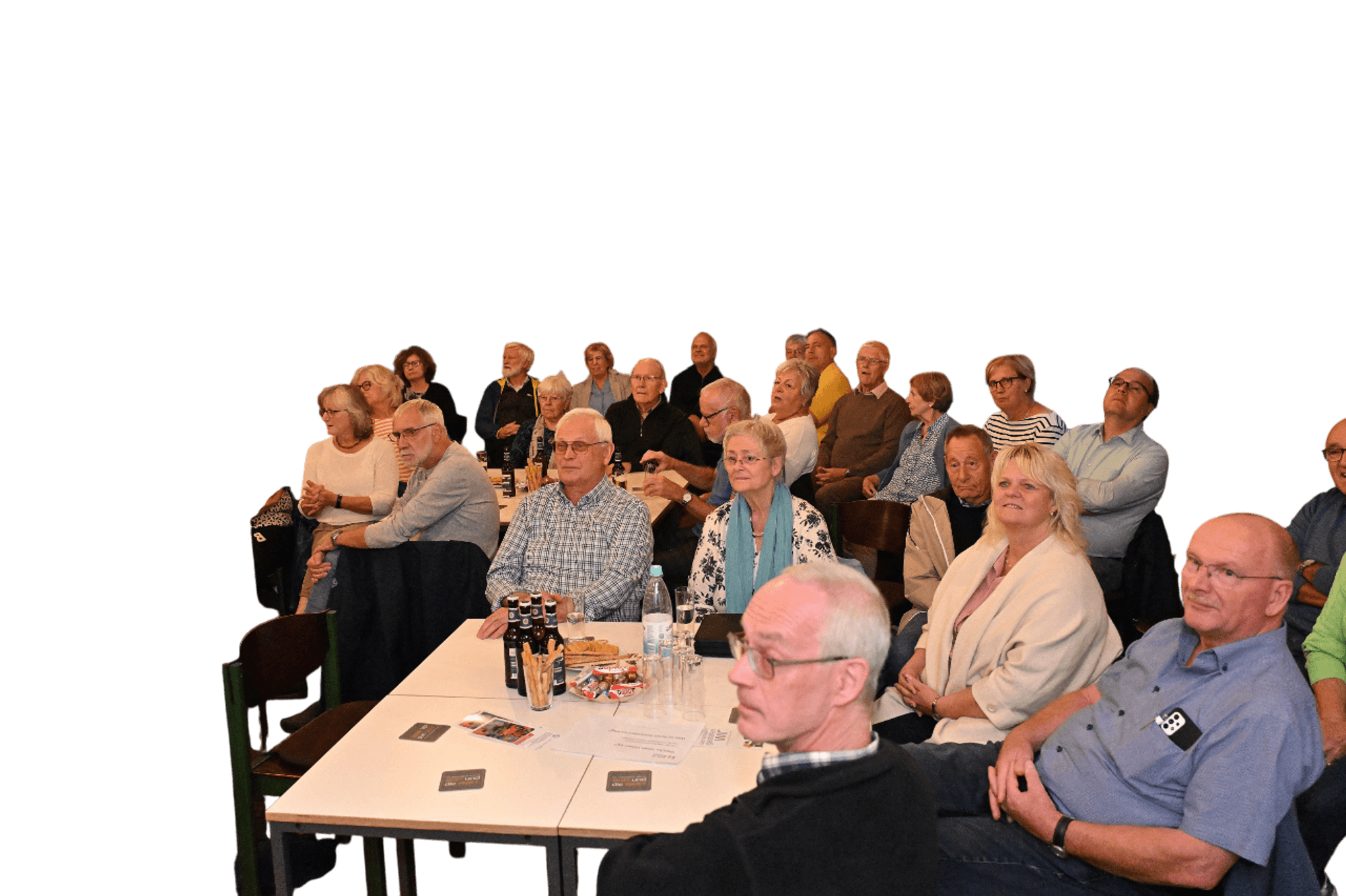 Viele ältere Menschen sitzen in einem Saal.