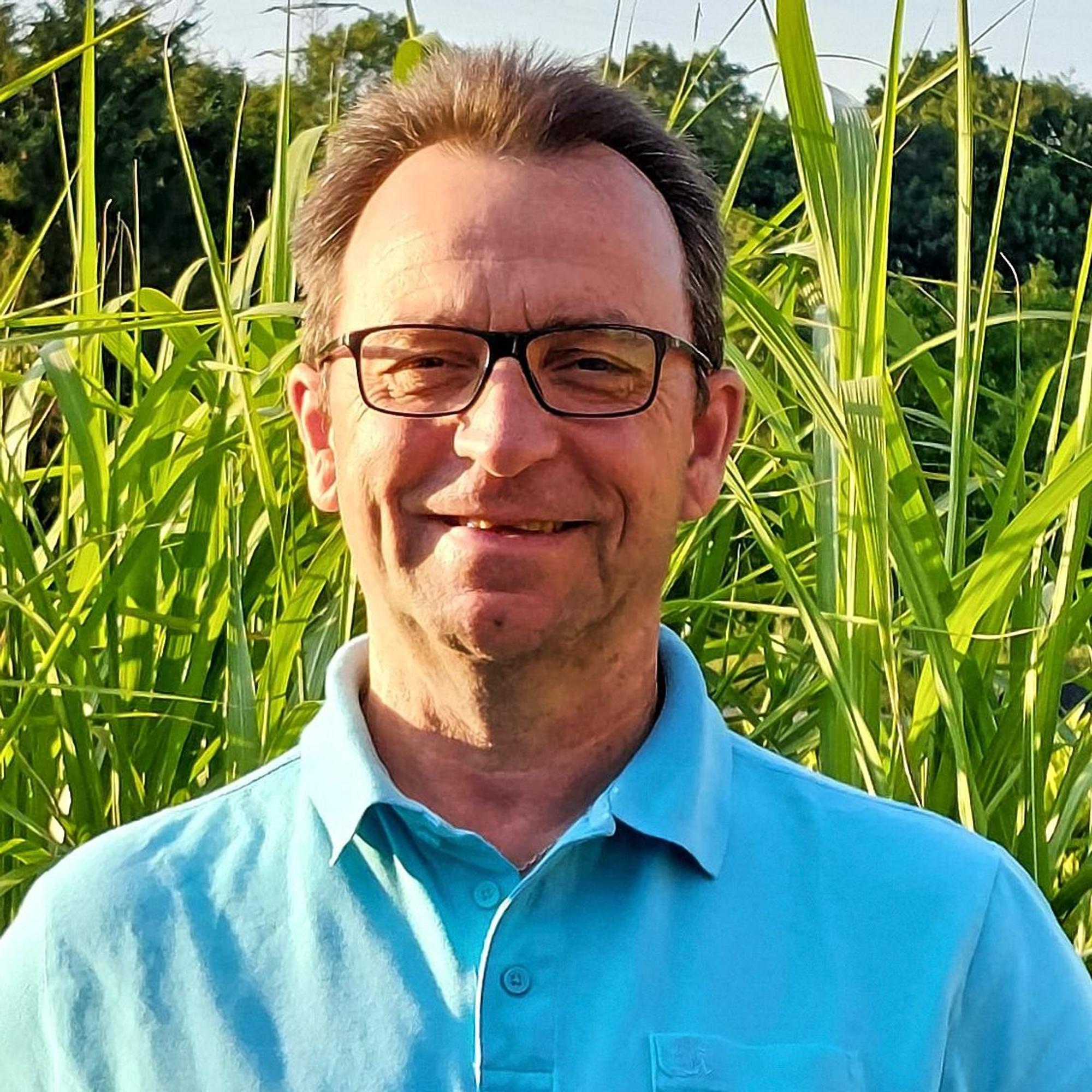 Heinz Bongard steht mitten im Grünen und lächelt in die Kamera.