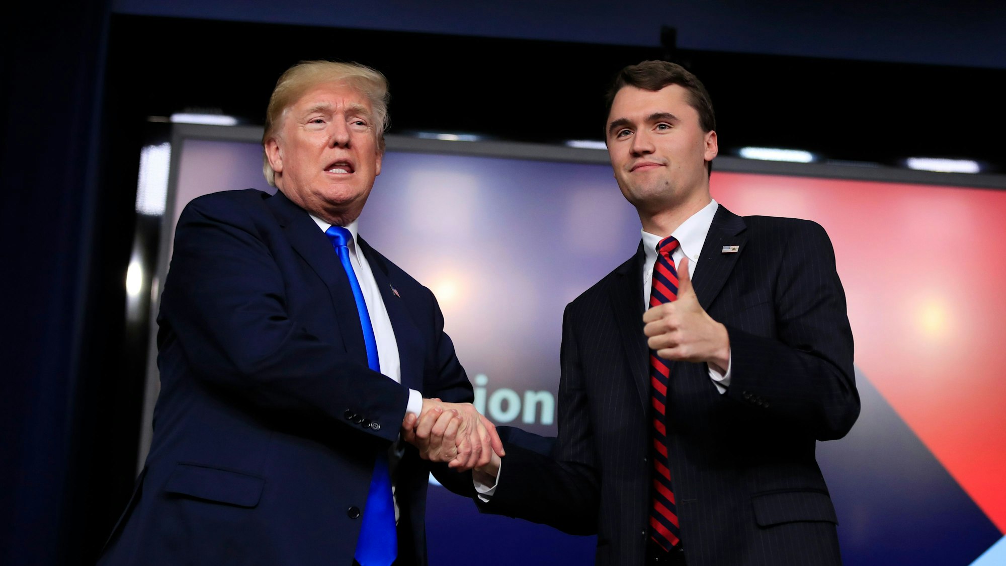 ARCHIV - 22.03.2018, USA, Washington: US-Präsident Donald Trump schüttelt dem Moderator Charlie Kirk während des Forums «Generation Next» im Weißen Haus im Eisenhower Executive Office Building auf dem Gelände des Weißen Hauses die Hand. Der rechtskonservative US-Podcaster und Aktivist Kirk ist bei einer Veranstaltung an einer Universität im westlichen US-Bundesstaat Utah angeschossen worden. Kirk sei laut einem Post der Utah Valley Universität in Orem auf der Plattform X getroffen und von seinen Sicherheitsleuten mitgenommen worden. Eine verdächtige Person befinde sich in Gewahrsam. Foto: Manuel Balce Ceneta/AP/dpa +++ dpa-Bildfunk +++