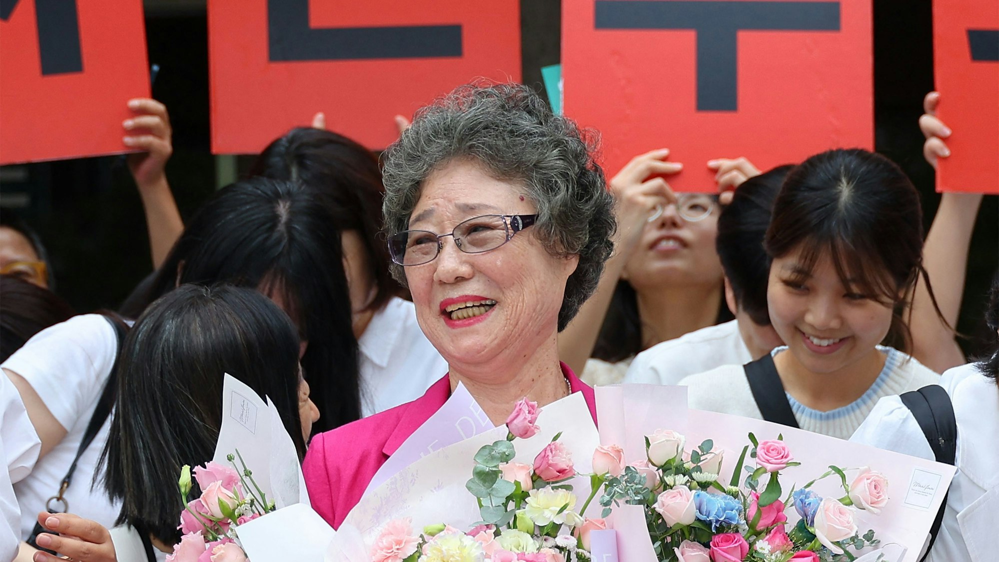 Choi Mal Ja wird vor dem Gerichtsgebäude mit Blumen und Spruchbändern gefeiert.