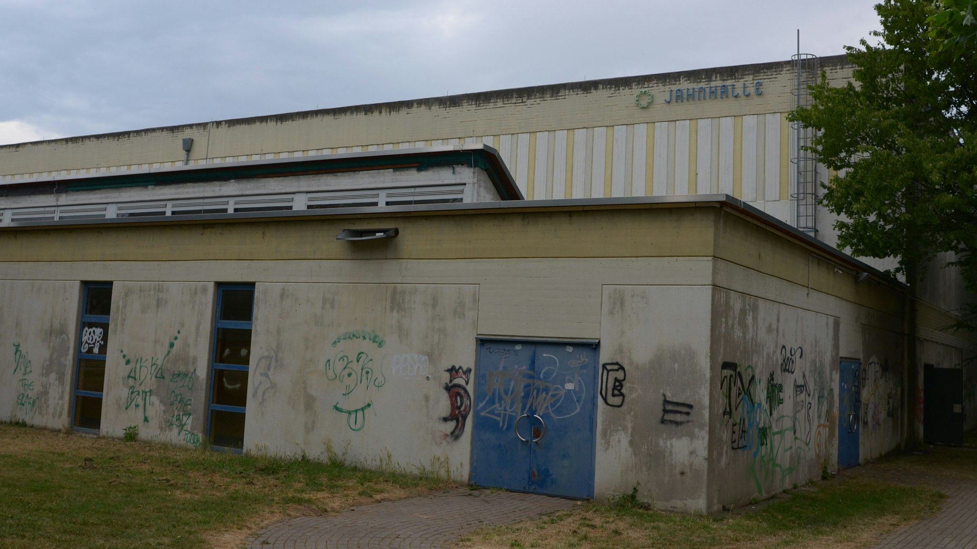 Das Bild zeigt den Zustand vor Beginn der Sanierung. Die Halle ist mit Farbschmierereien verunstaltet.