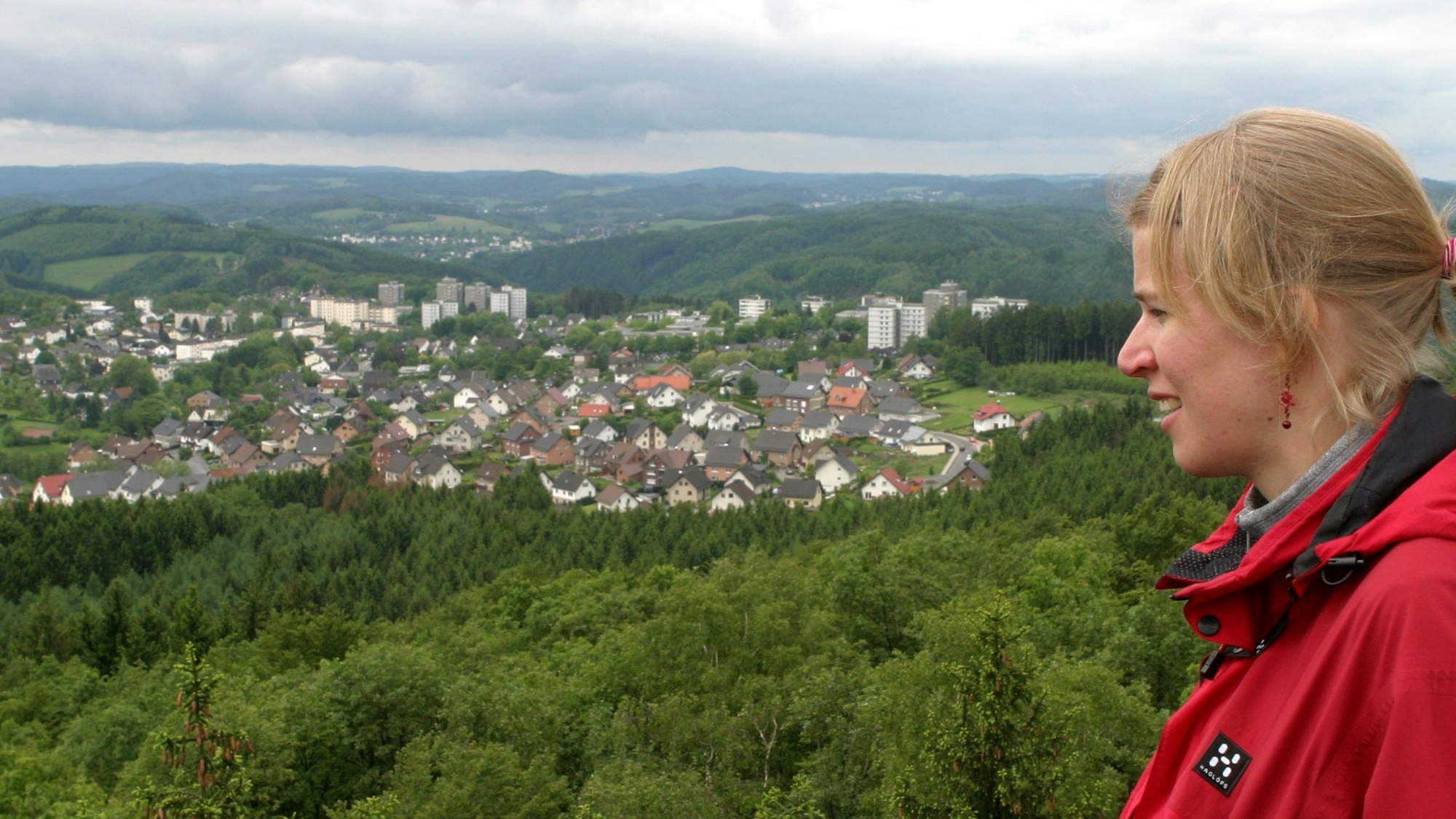Eine Frau schaut vom Aussichtsturm „Auf dem Knollen“ über Bergneustadt-Hackenberg und das Bergische Land.