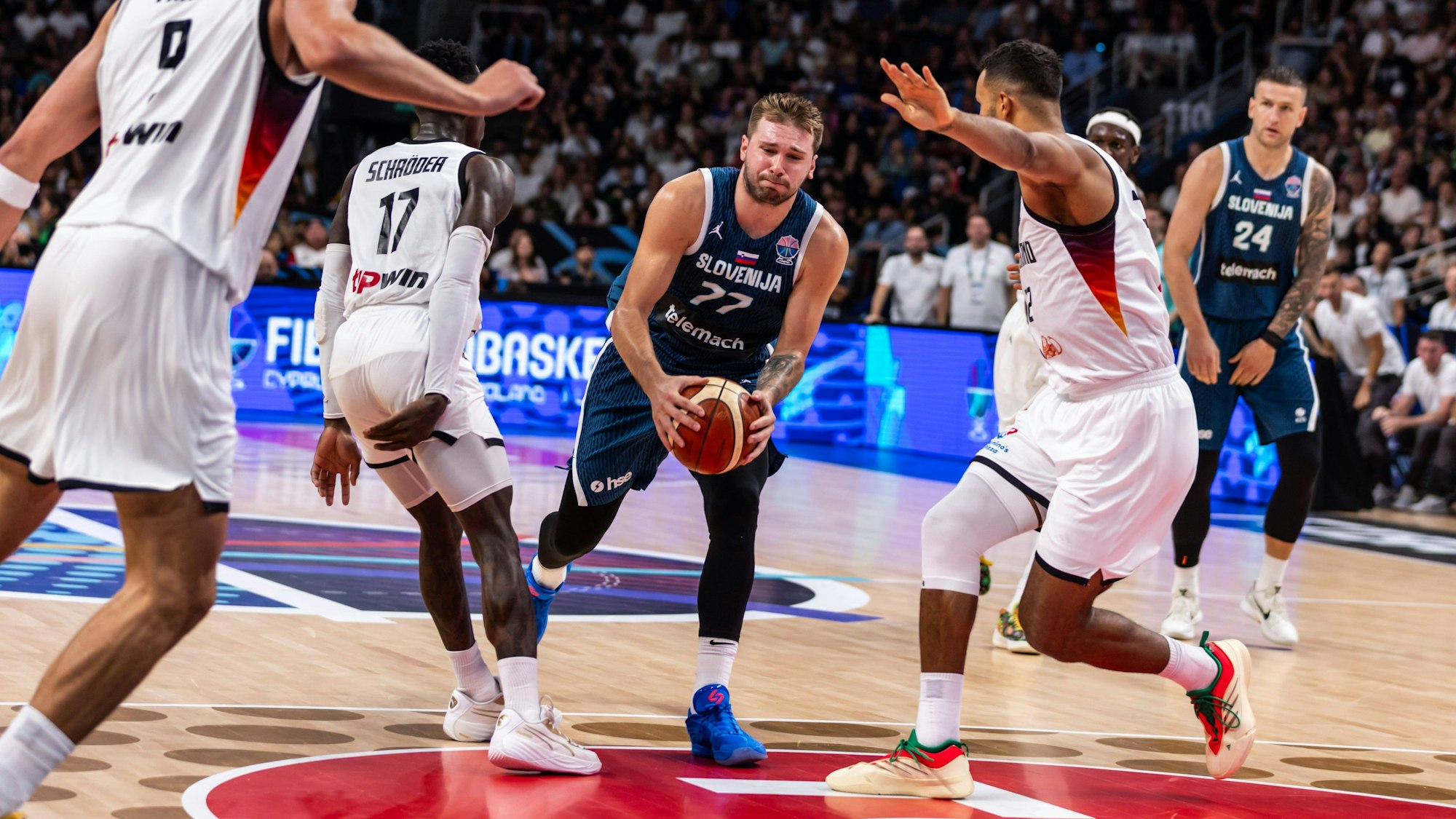 Luka Doncic mit dem Ball inmitten dreier deutscher Spieler.